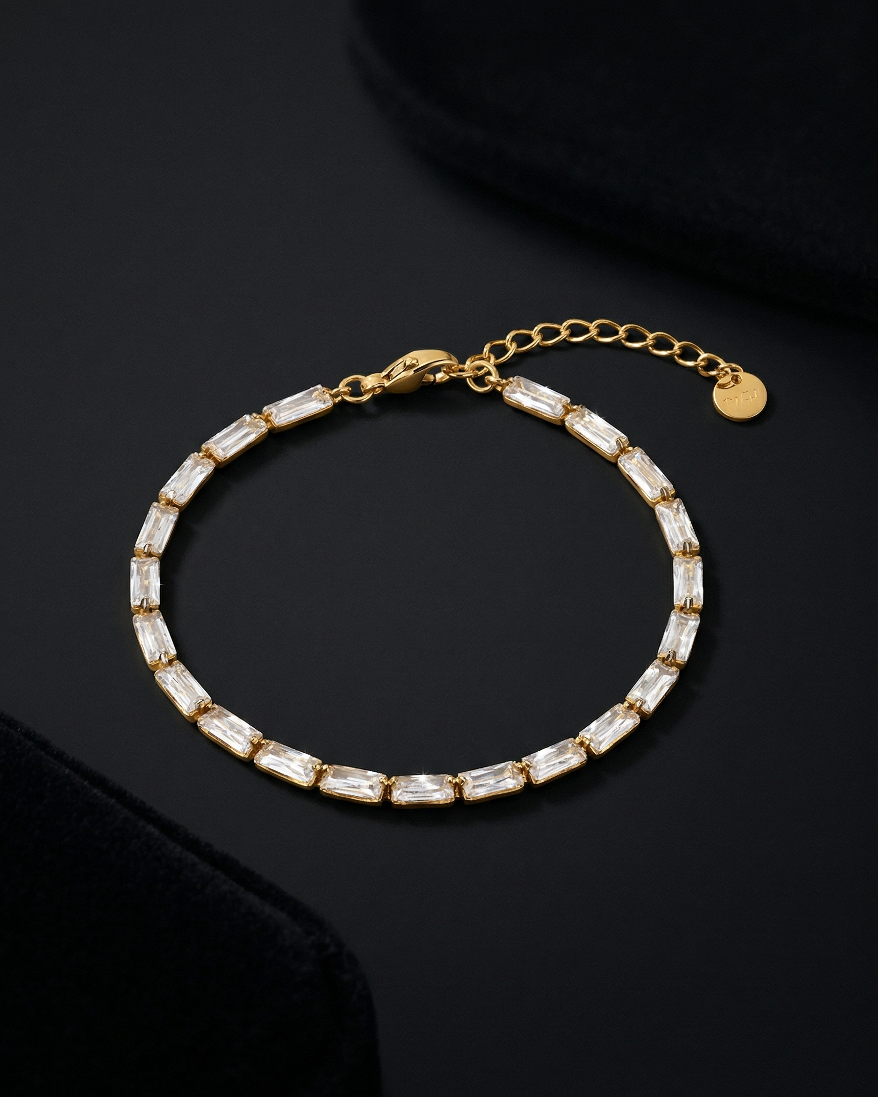 Gold bracelet with clear stones on a dark surface