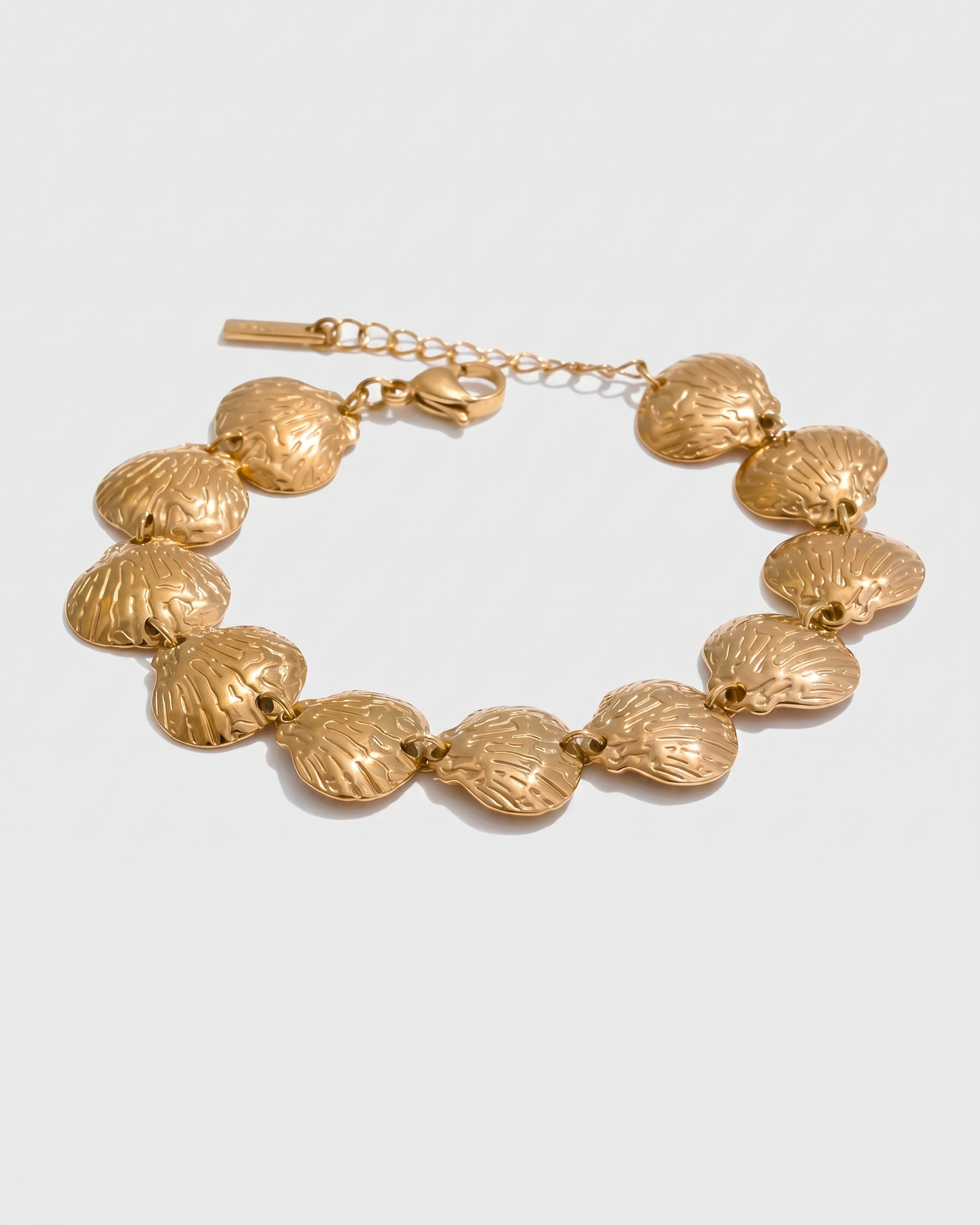 Gold bracelet with textured links on a light gray background