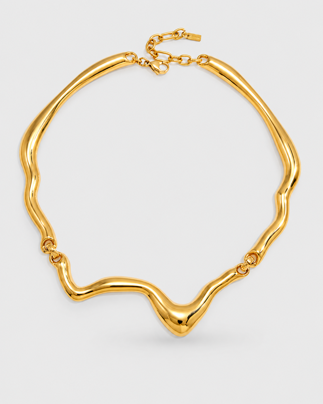 A chunky gold-toned necklace with a wavy, organic silhouette and a small clasp extension chain, shown on a light gray background.