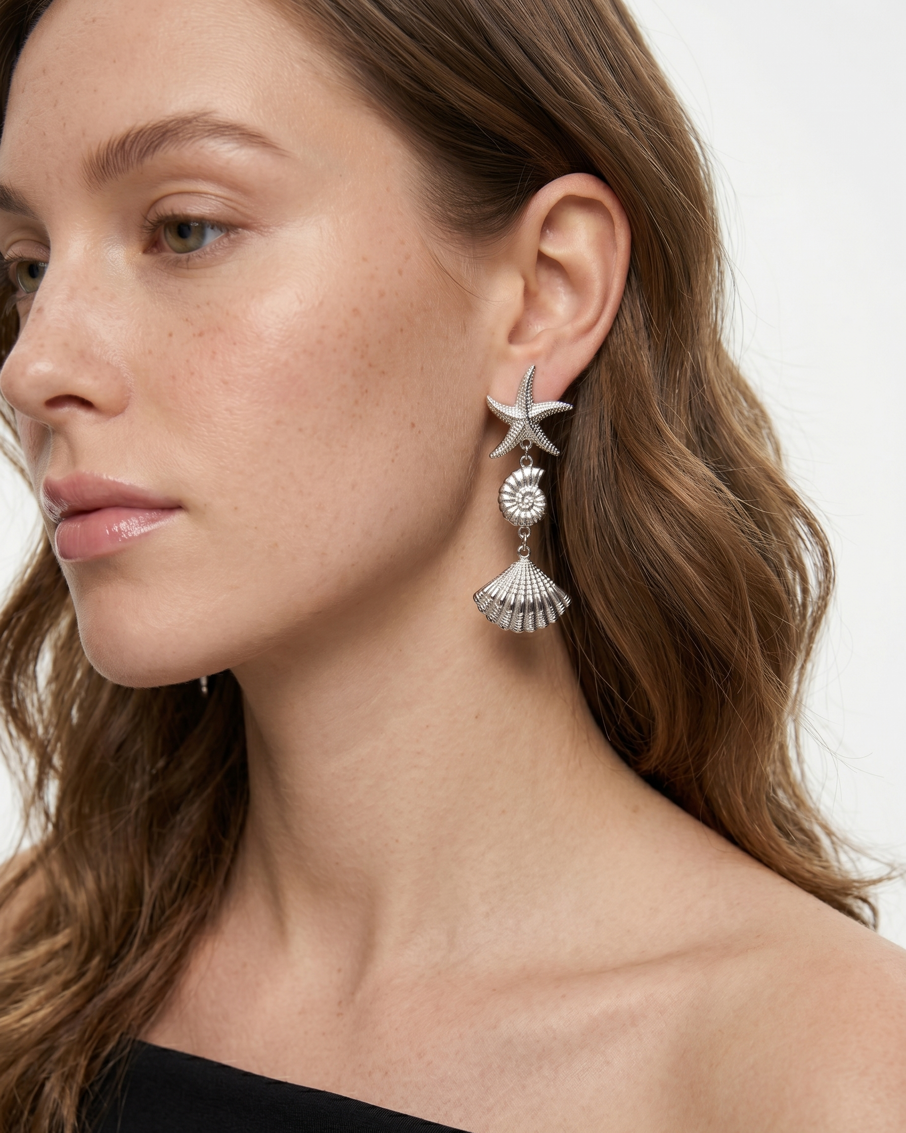 Close-up of a woman wearing star-shaped earrings with a white background