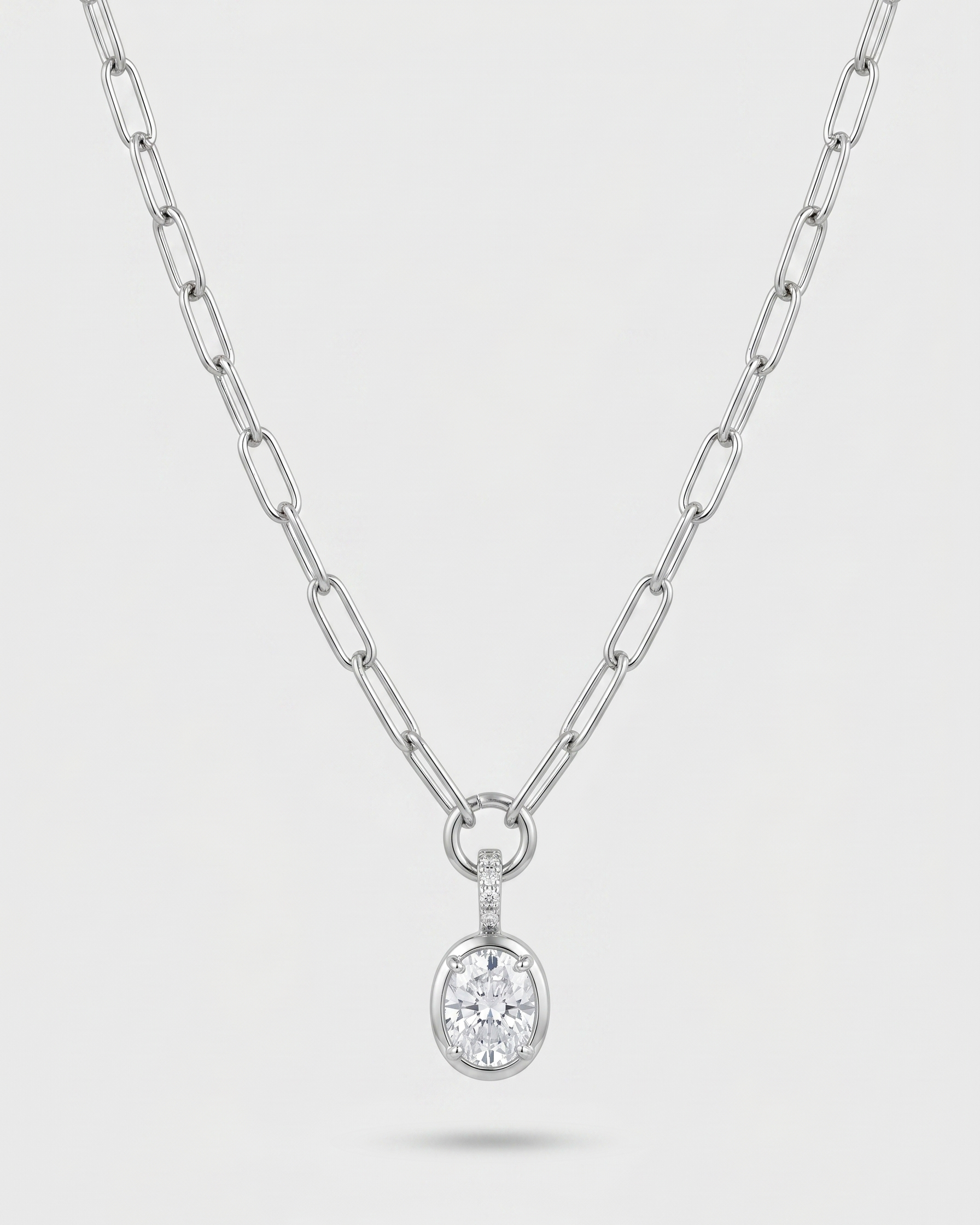 Silver necklace with a round pendant on a light gray background
