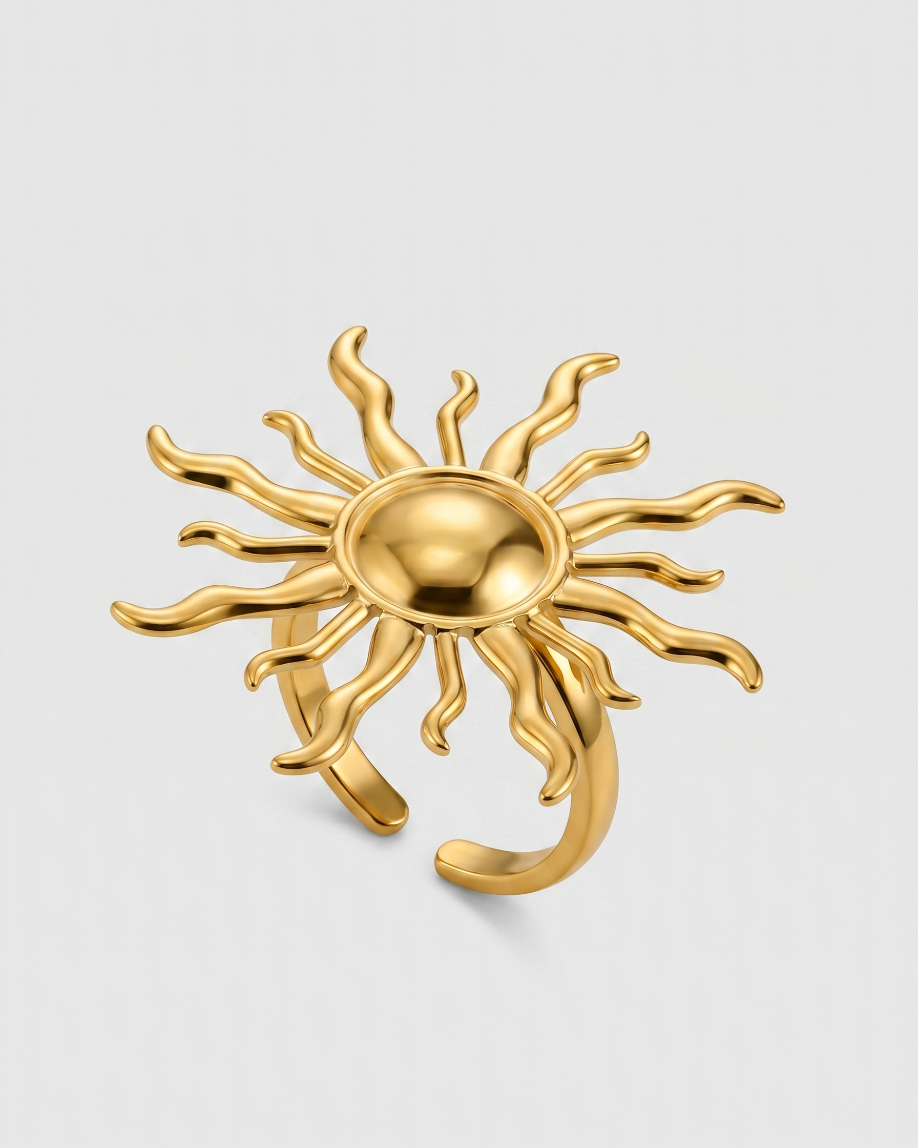 Gold sun-shaped ring on a light gray background