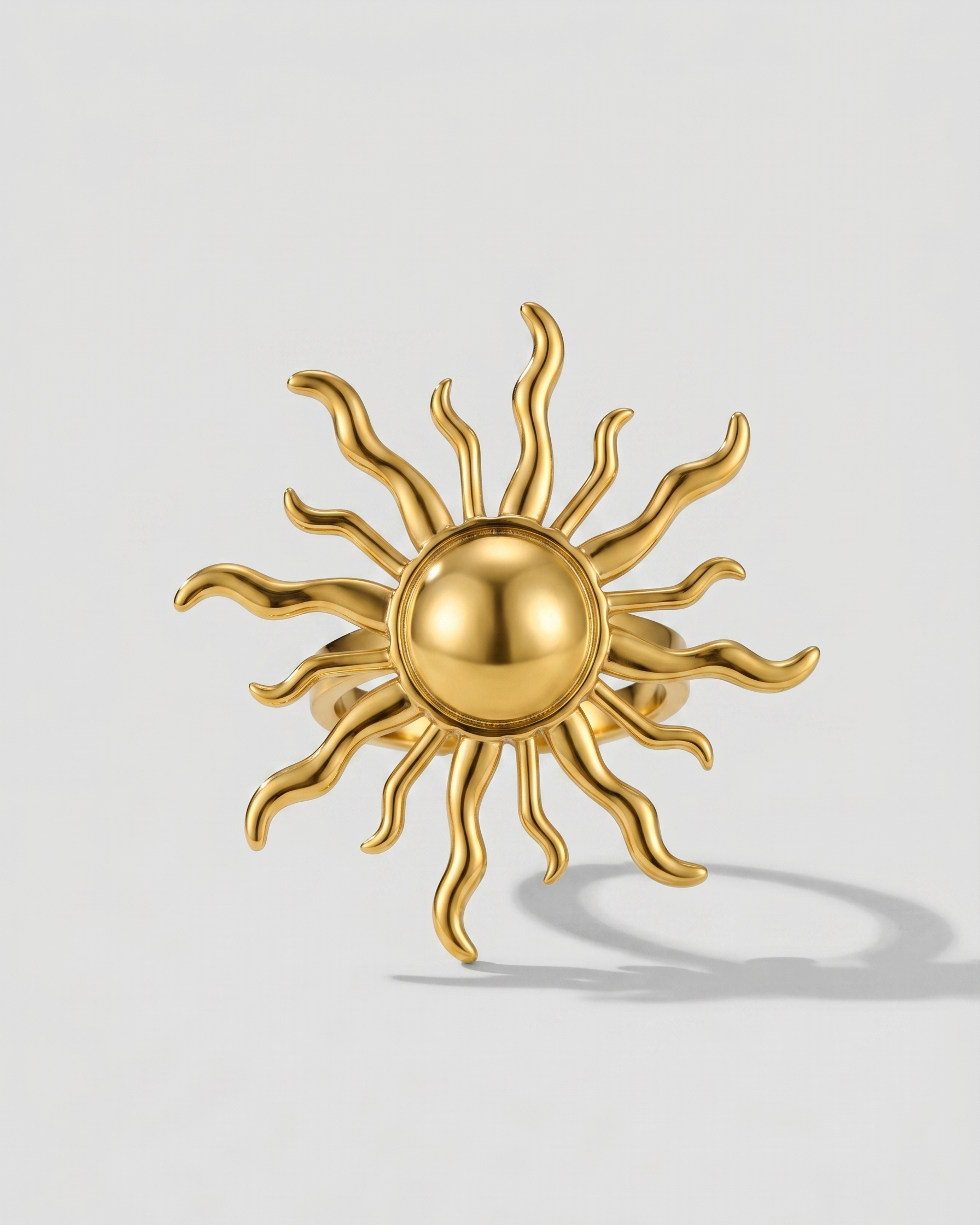 Gold sun-shaped earring on a light gray background