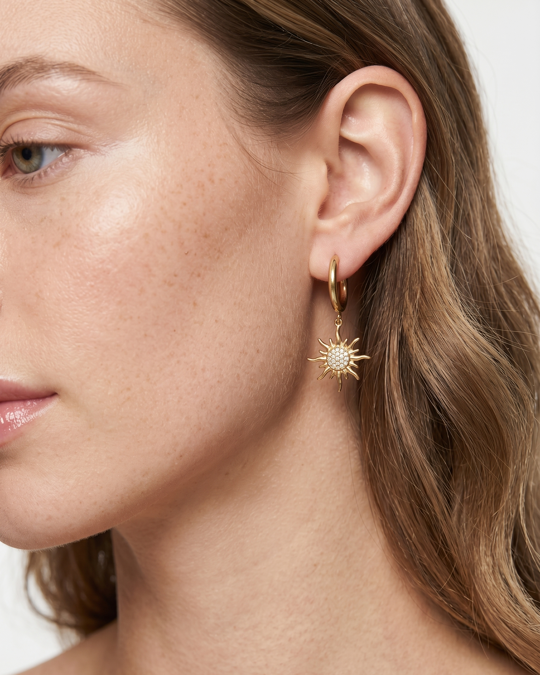 Close-up of a woman wearing a gold earring with a star design.