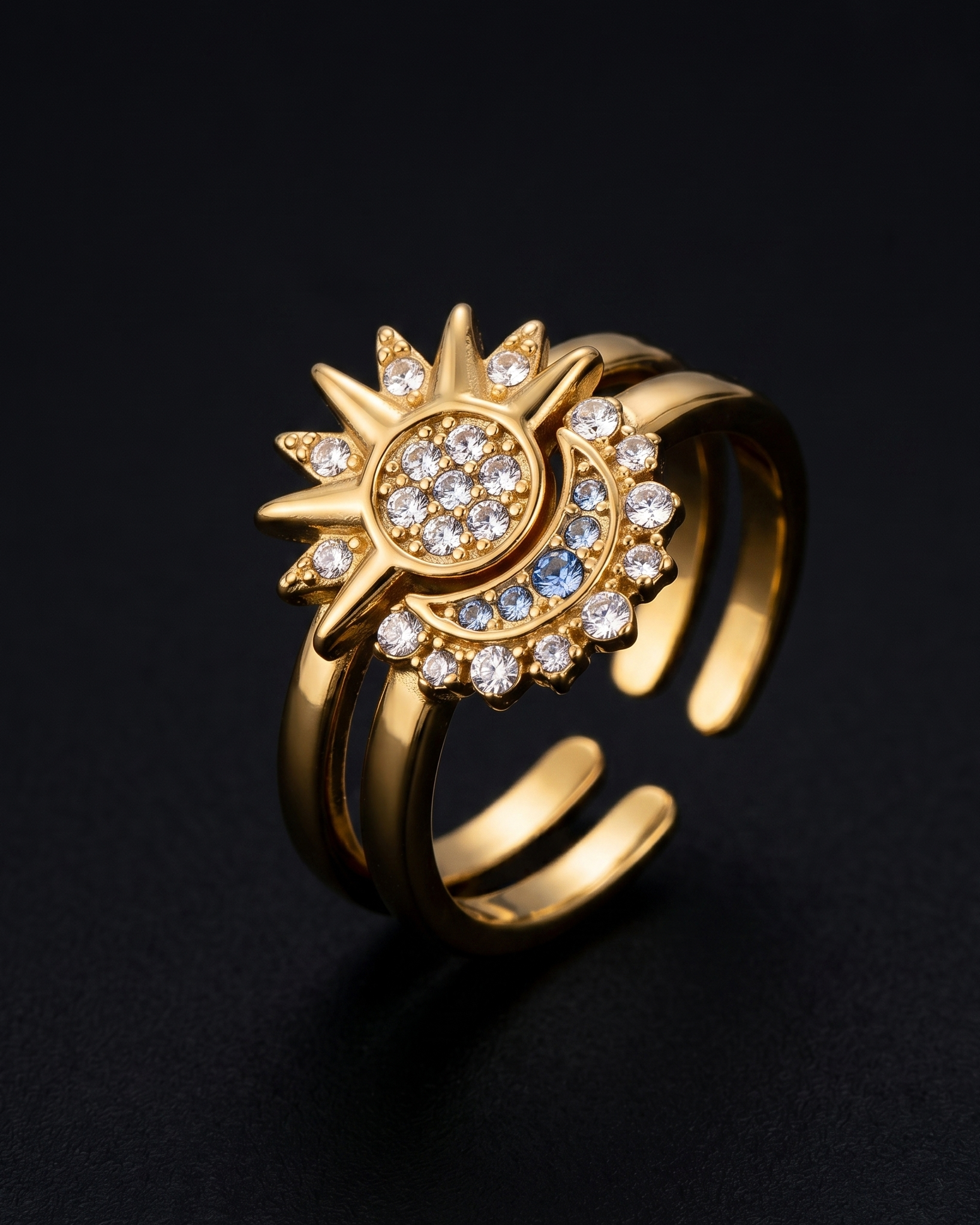 Gold ring with sun design and embedded stones on a black background