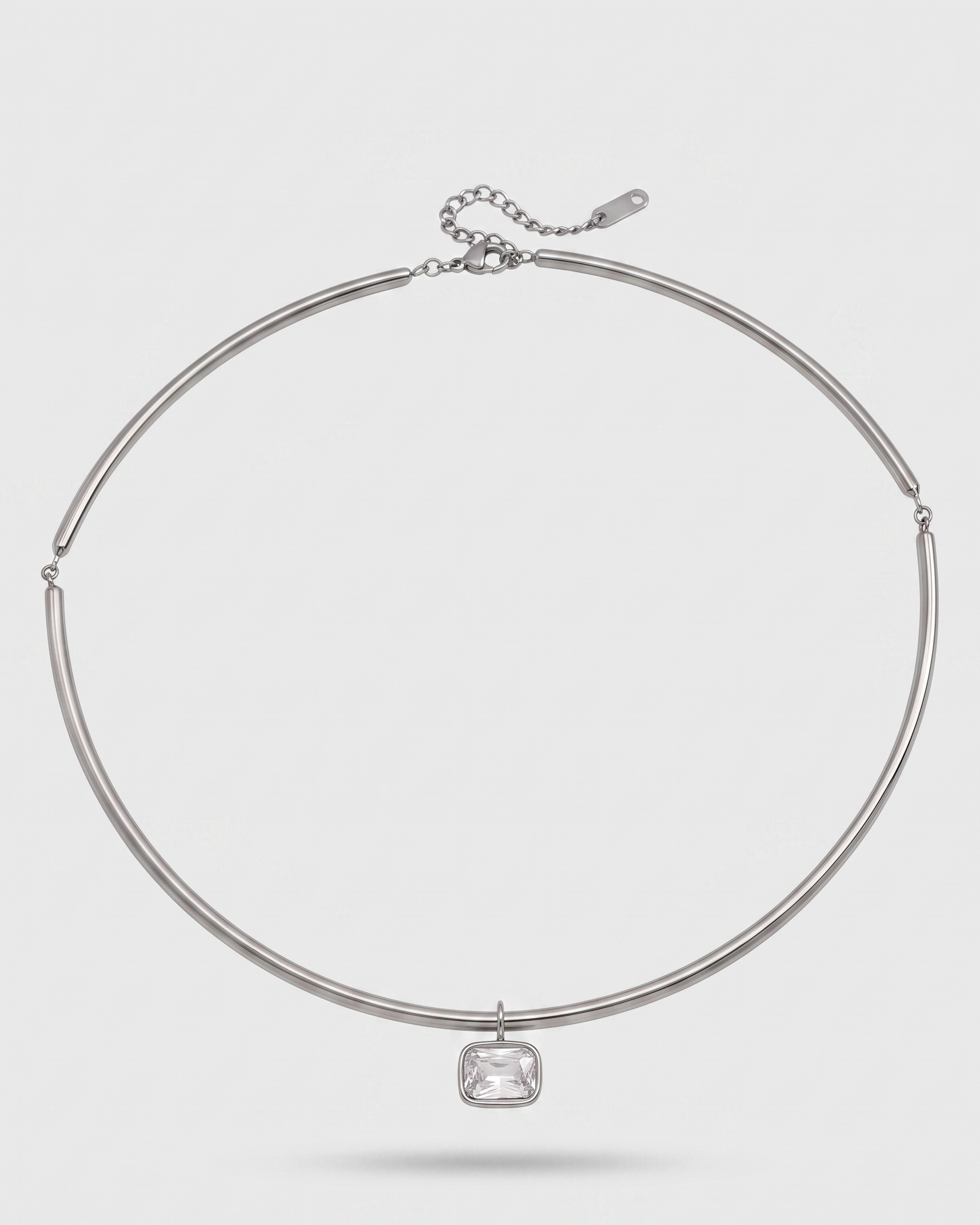Silver necklace with a clear gemstone on a white background