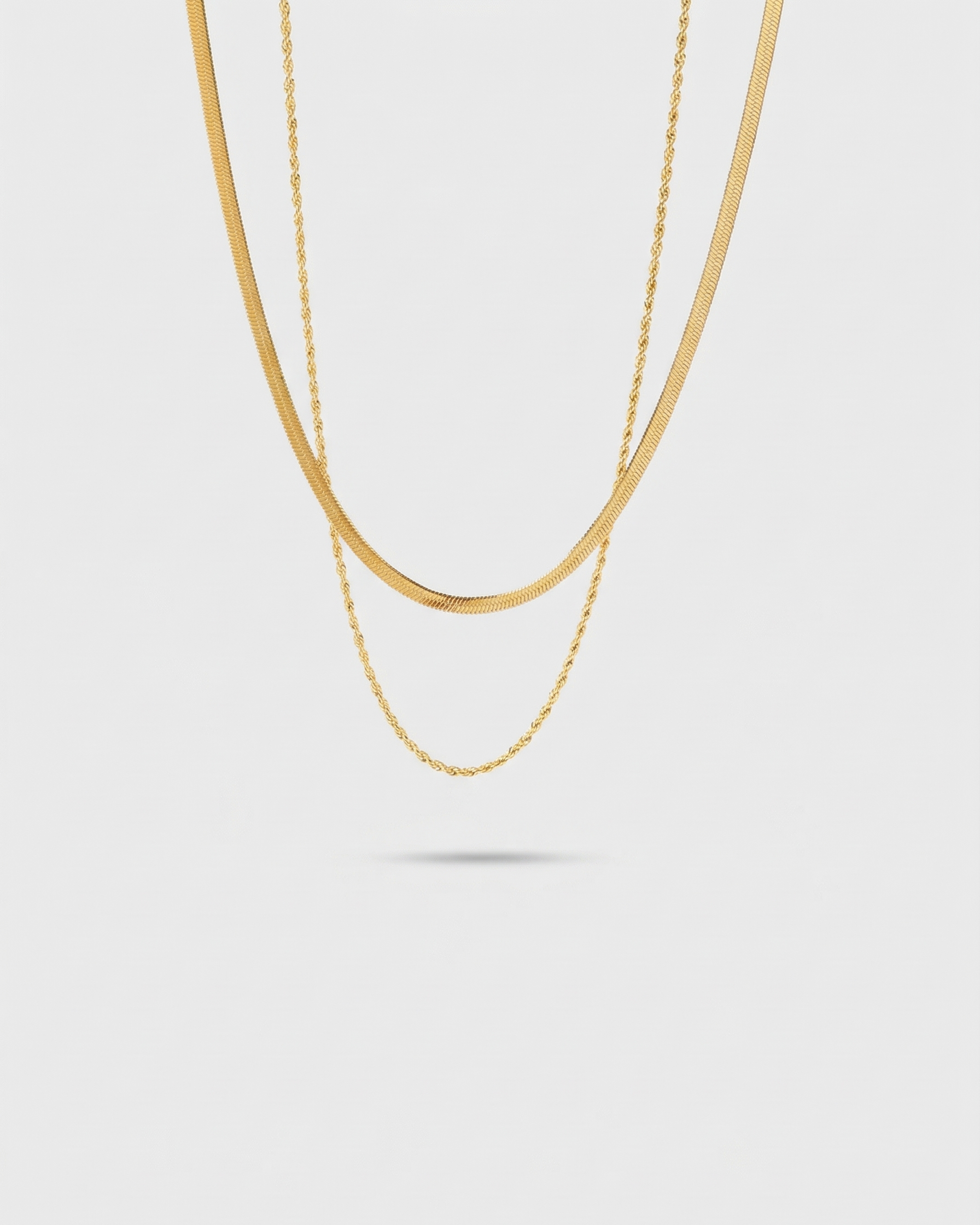 Gold chain necklace on a light gray background