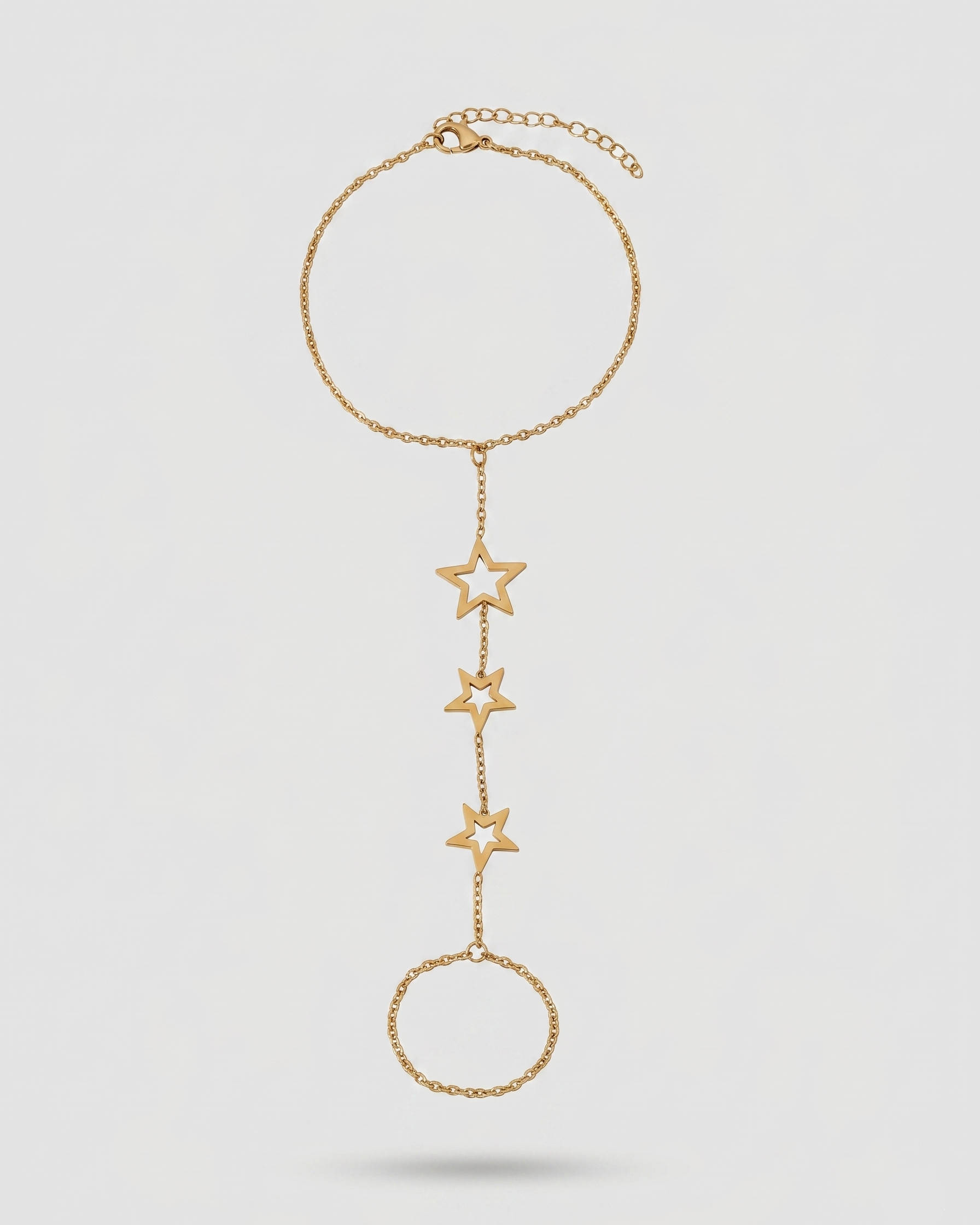 Gold star necklace on a light gray background