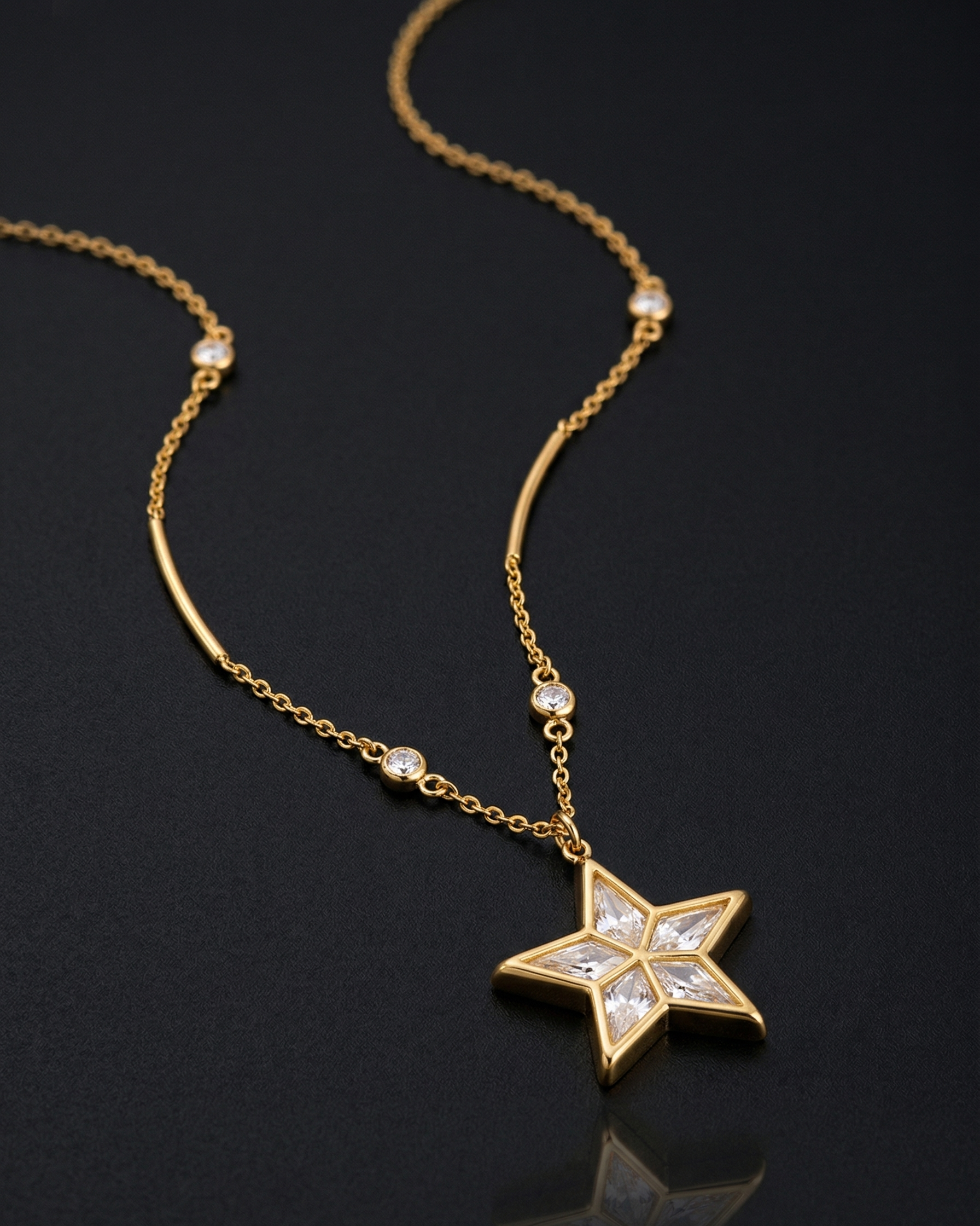 Gold necklace with a star-shaped pendant on a black background