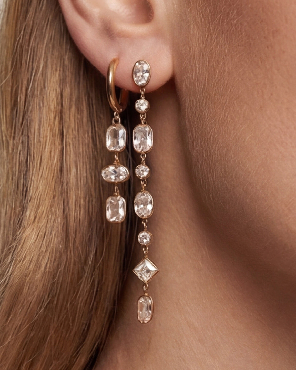 Close-up of a woman wearing elegant diamond earrings with a soft focus on hair and skin.