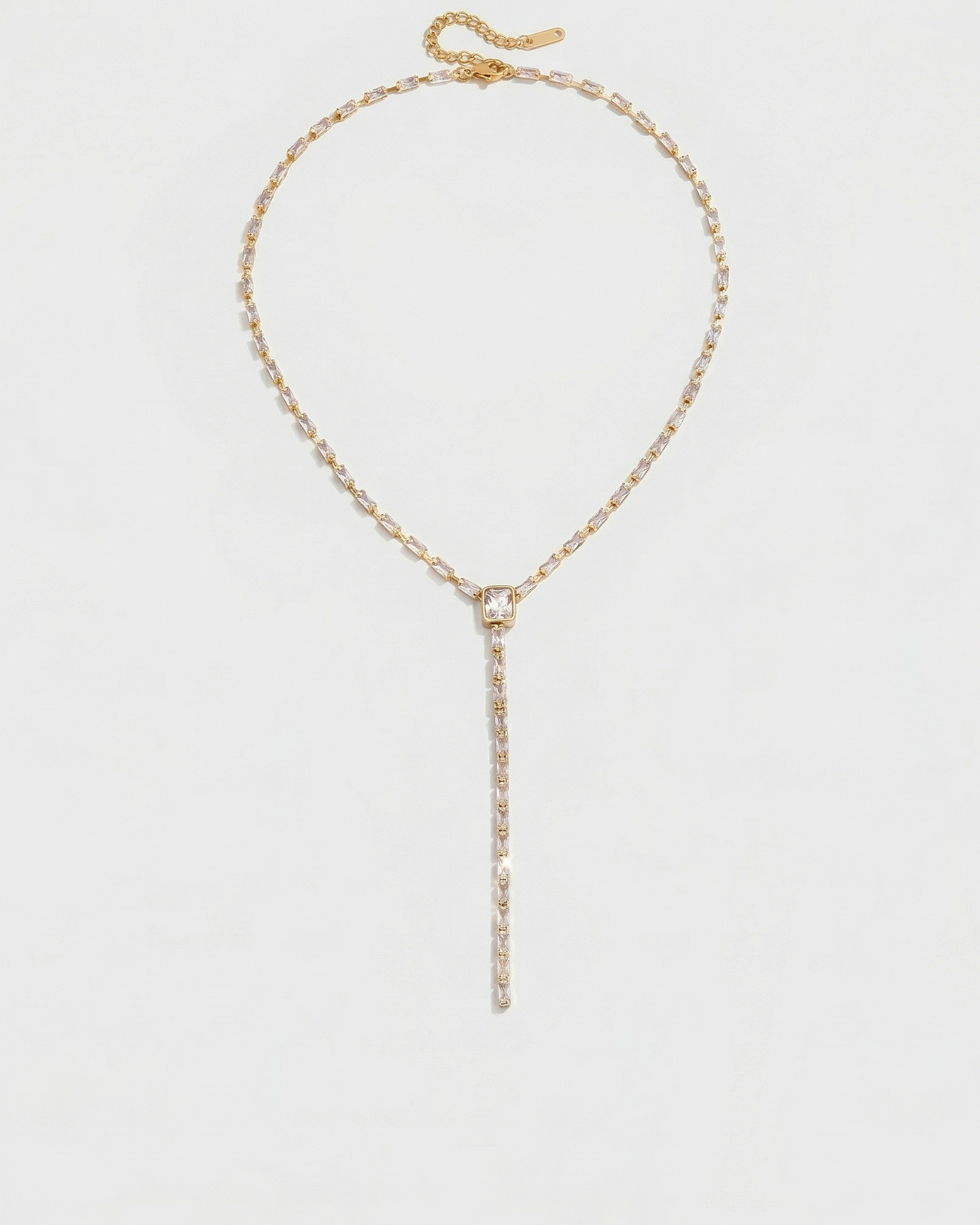 Gold necklace with a pendant on a light gray background