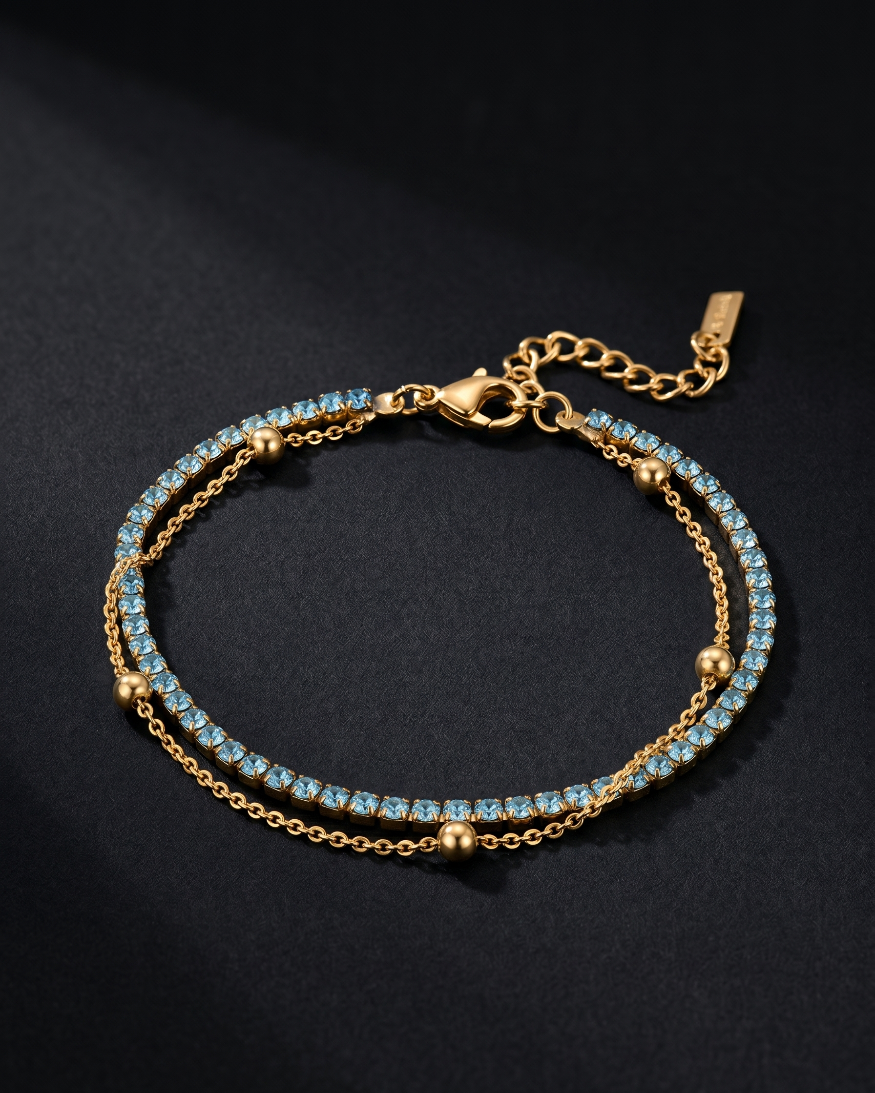 Gold bracelet with blue stones on a black background