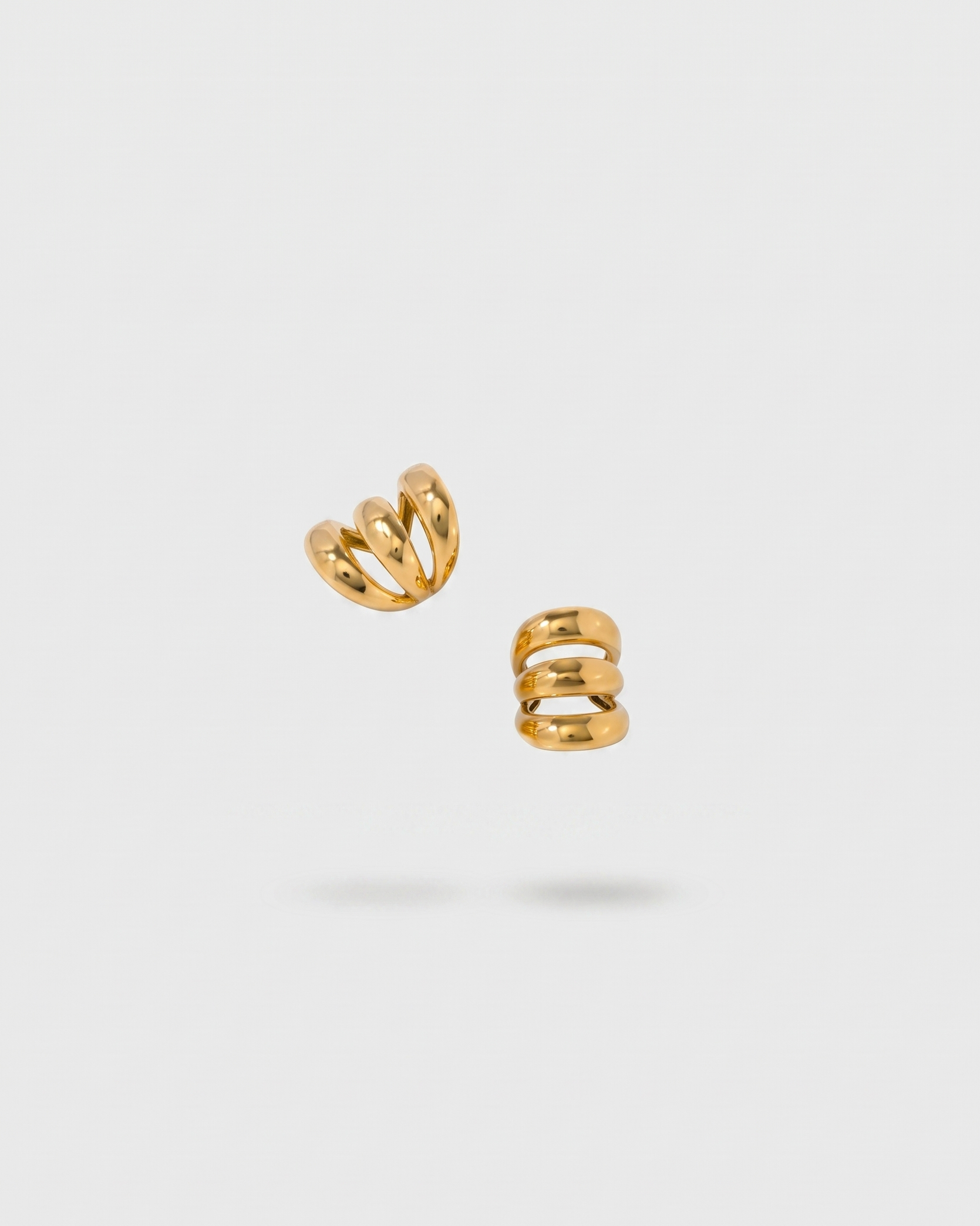 Pair of gold spiral earrings on a light gray background