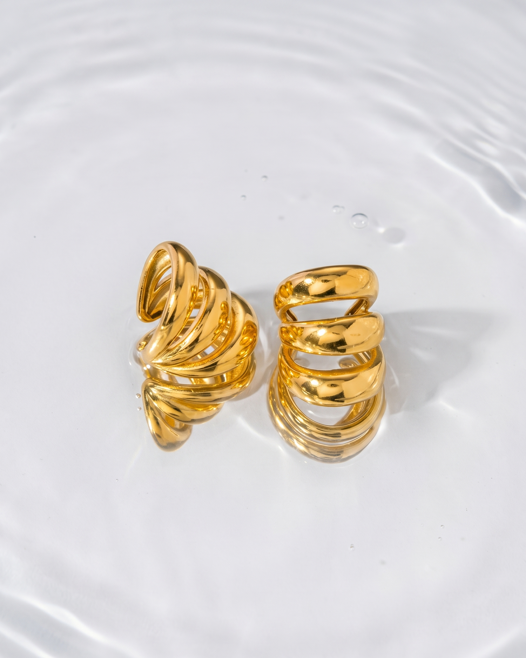 Gold spiral earrings on a white background