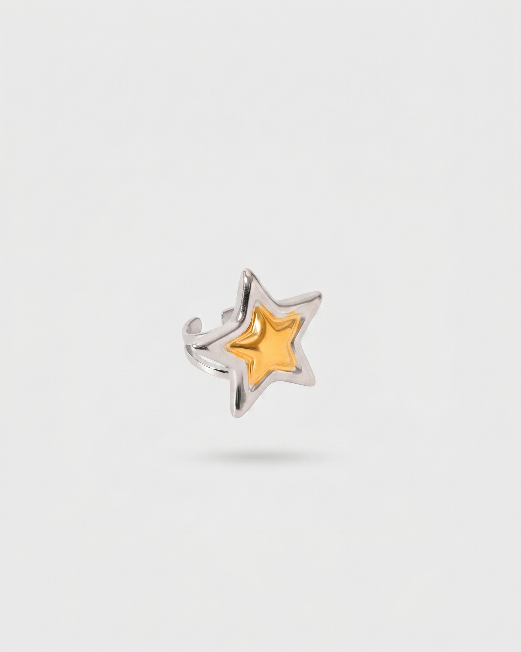Star-shaped ring with a gold center and silver outline on a white background