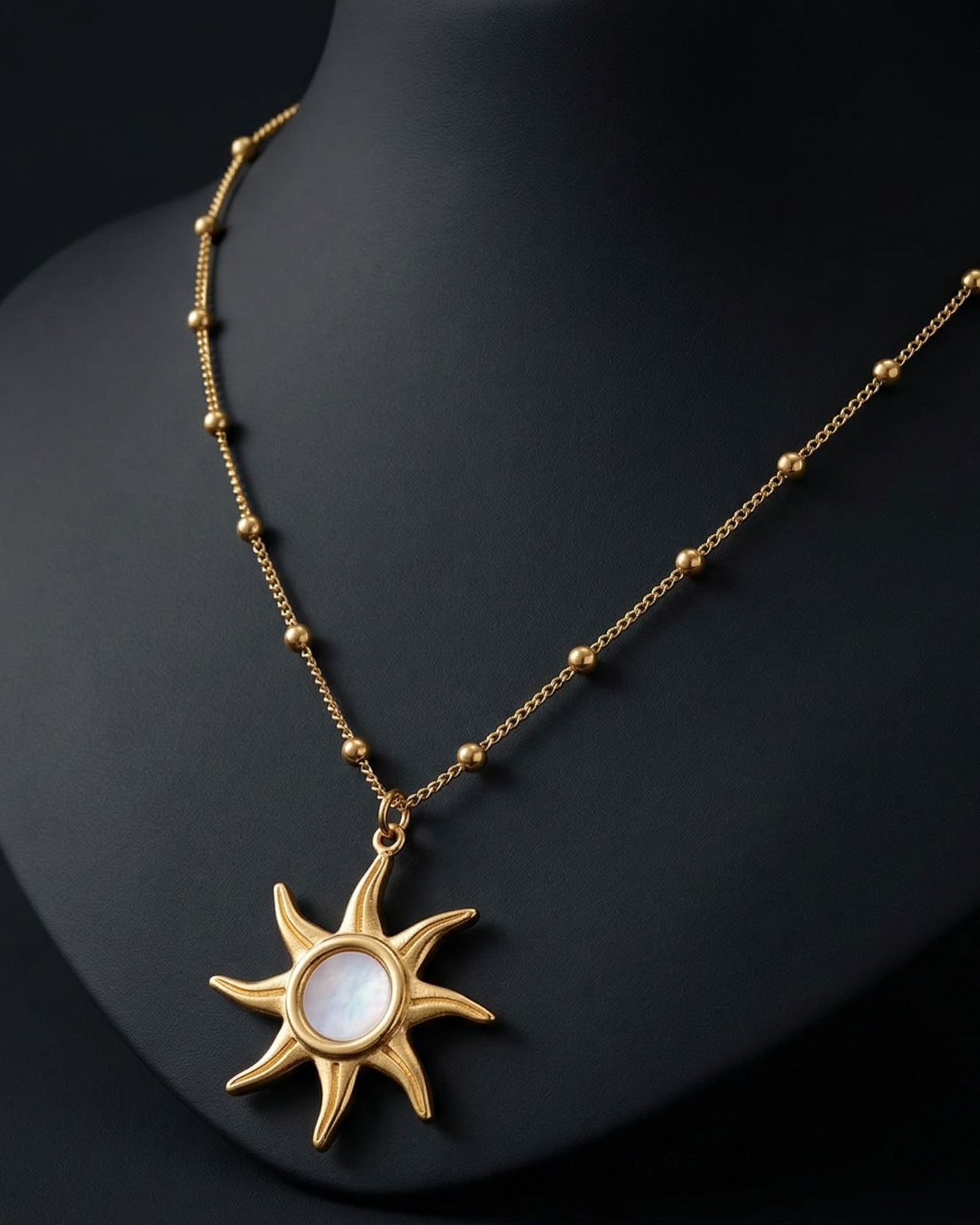 Gold necklace with a sun-shaped pendant on a black background