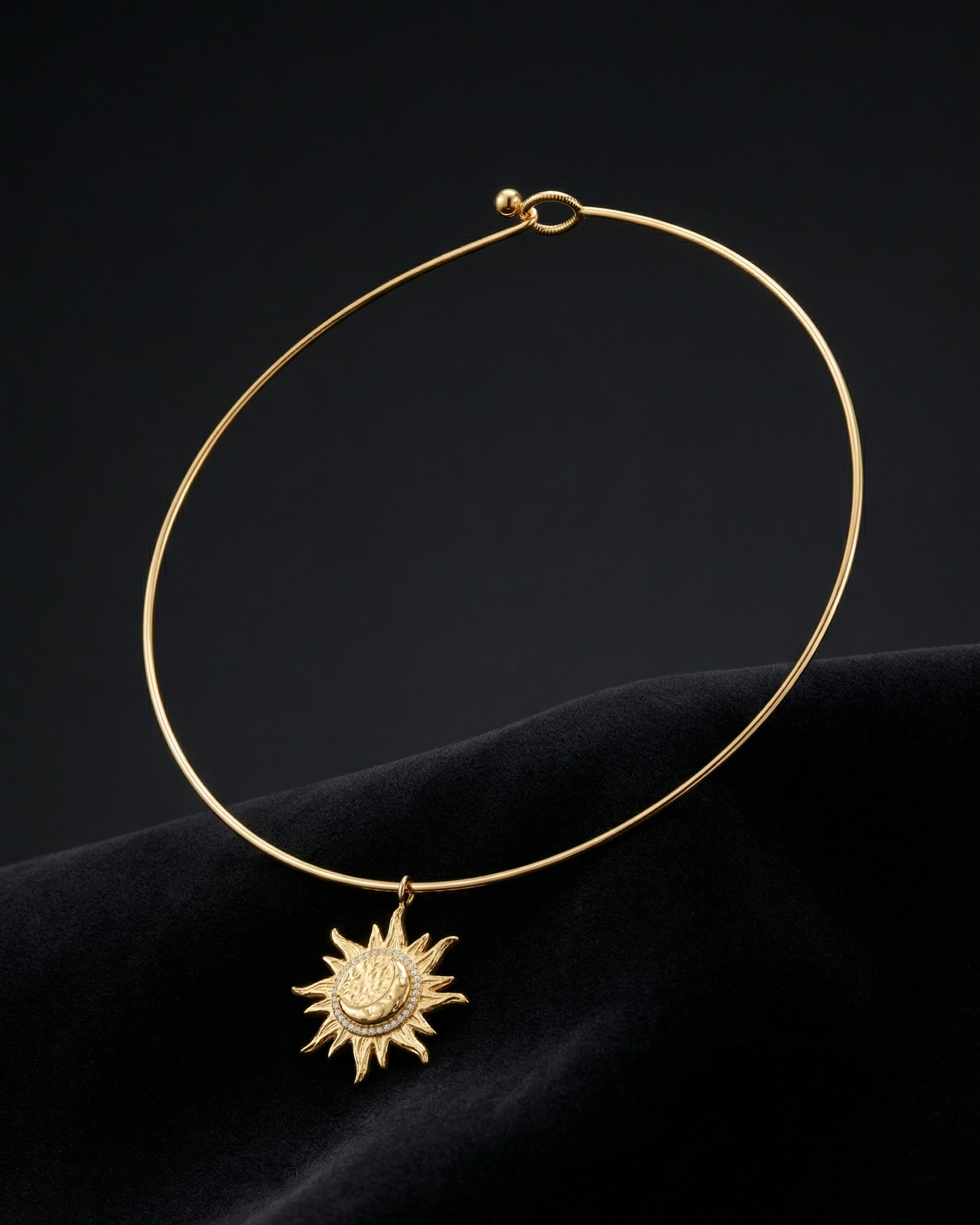 Gold necklace with a sun pendant on a dark background