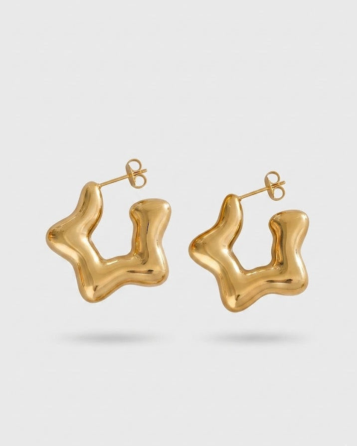 Gold hoop earrings on a light gray background