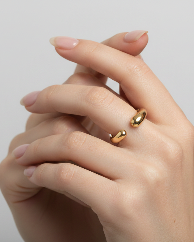 Gold ring on a hand against a plain background