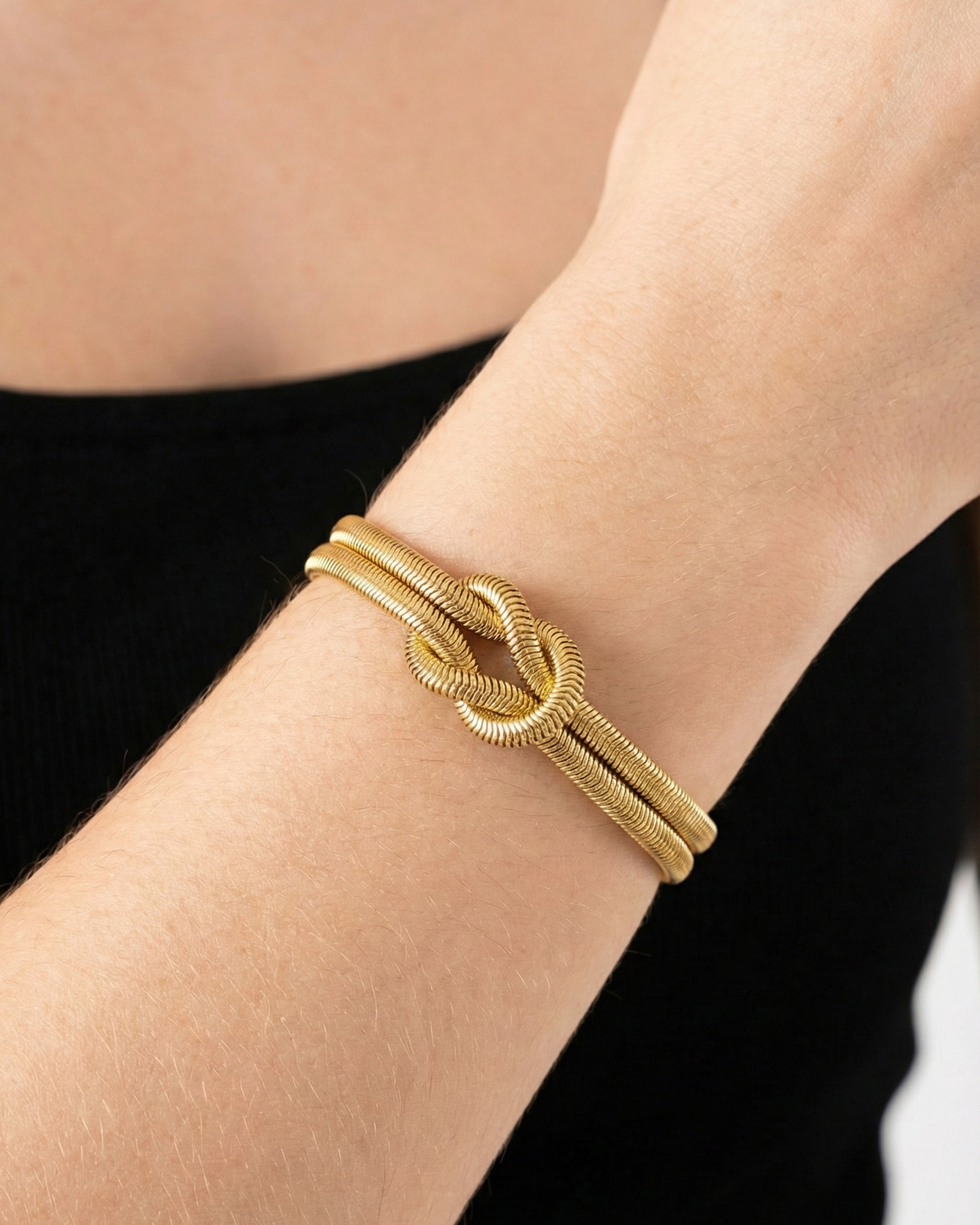 Gold bracelet on a person's wrist with a blurred background