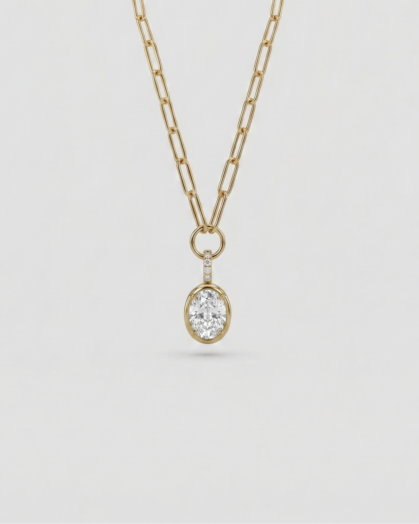 Gold necklace with a diamond pendant on a light gray background