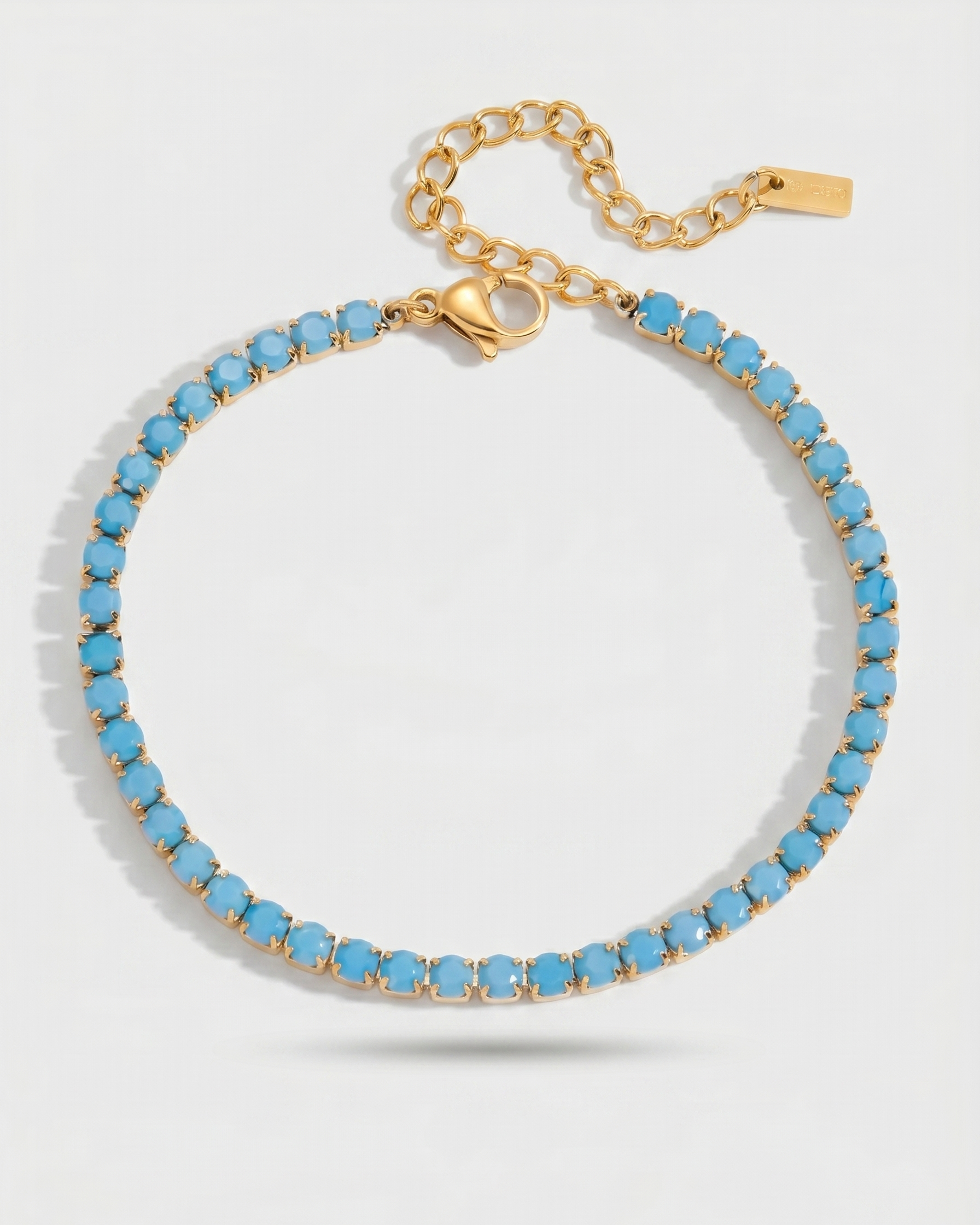 Gold bracelet with blue beads on a white background
