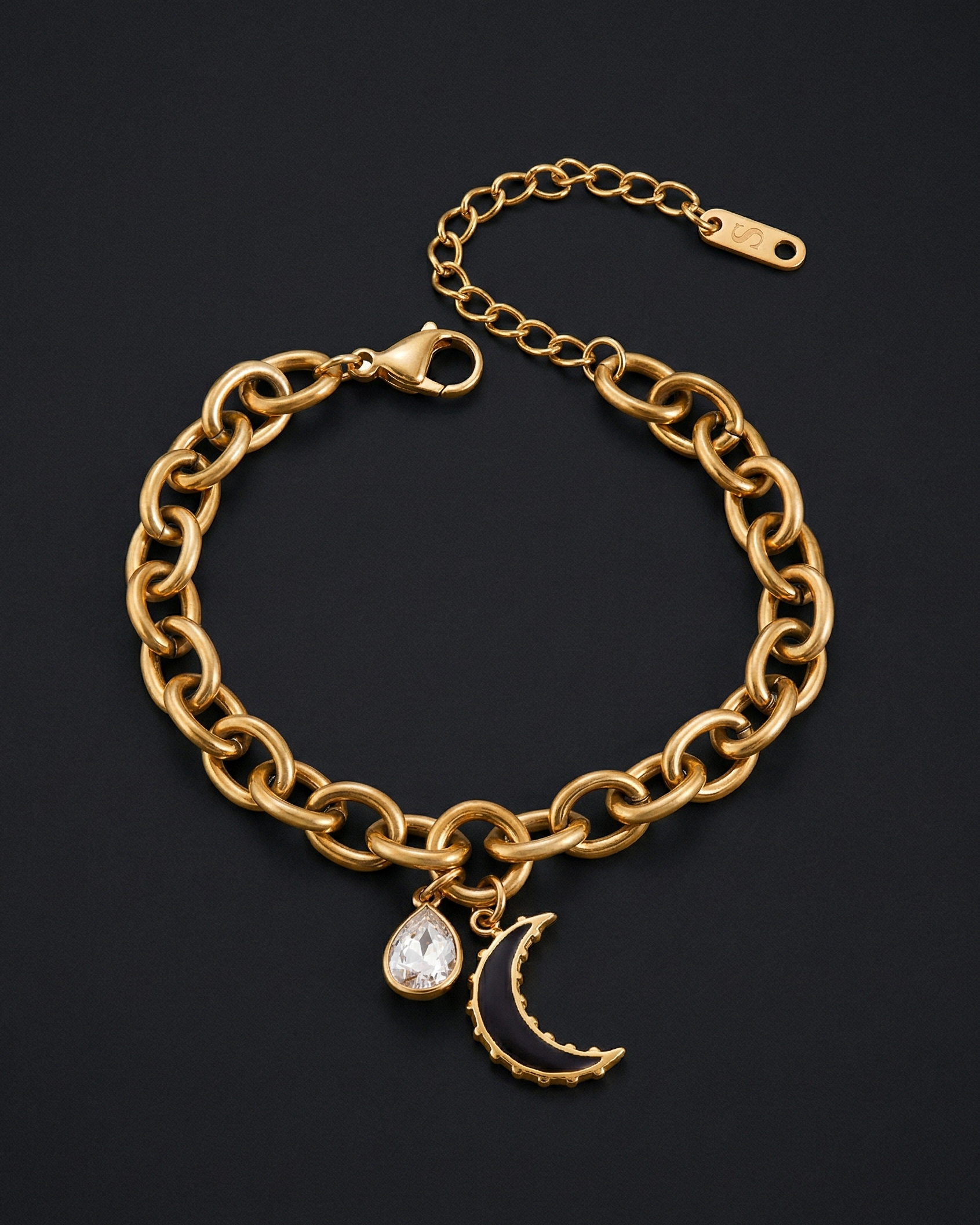 Gold chain bracelet with a moon and star charm on a black background