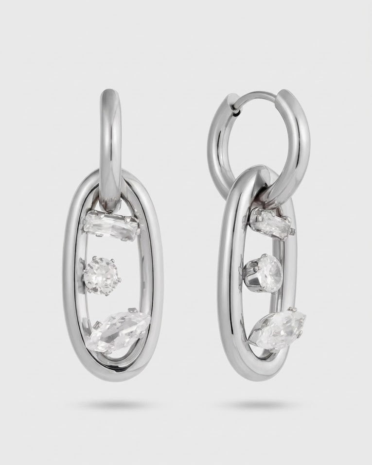 Silver hoop earrings with clear gemstones on a light gray background