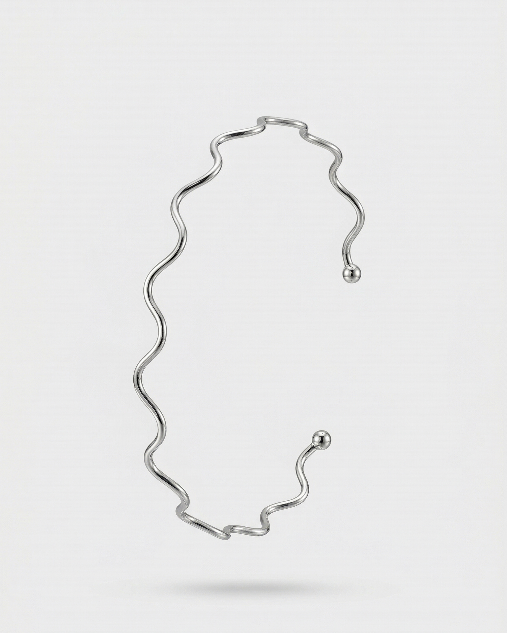 Silver necklace on a light gray background