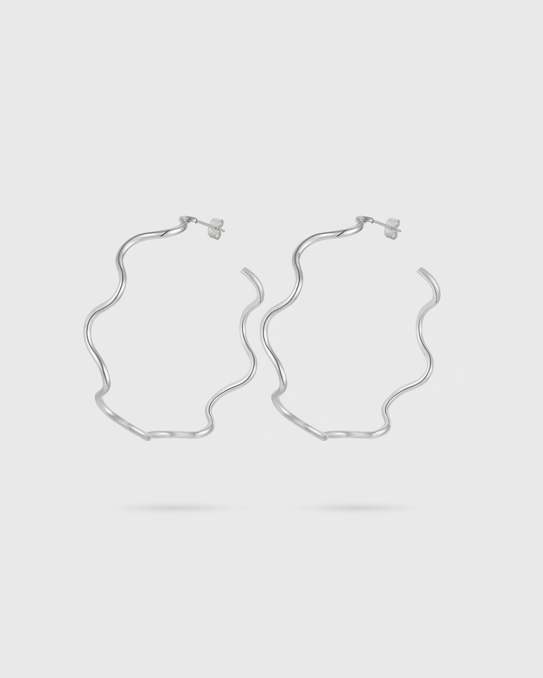 Pair of silver hoop earrings on a light gray background