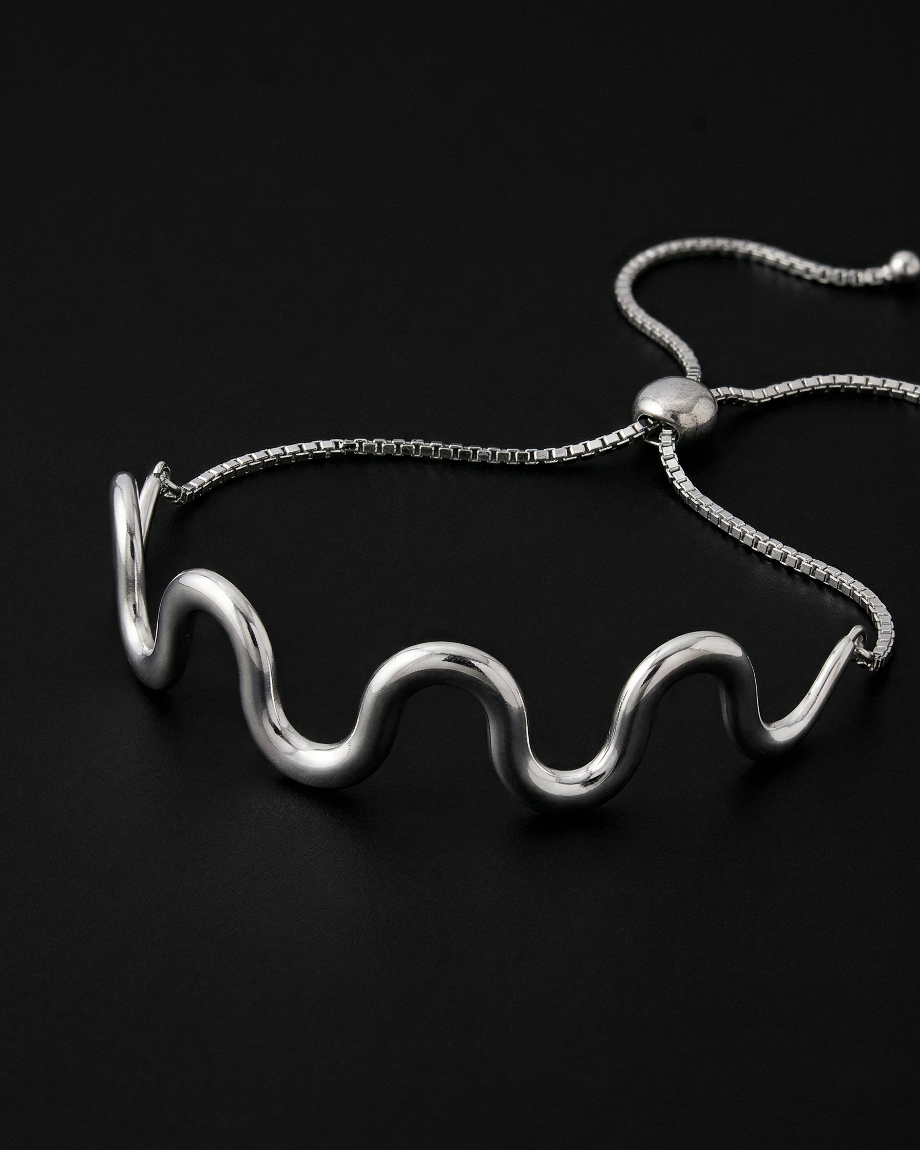 Silver wavy necklace on a black background