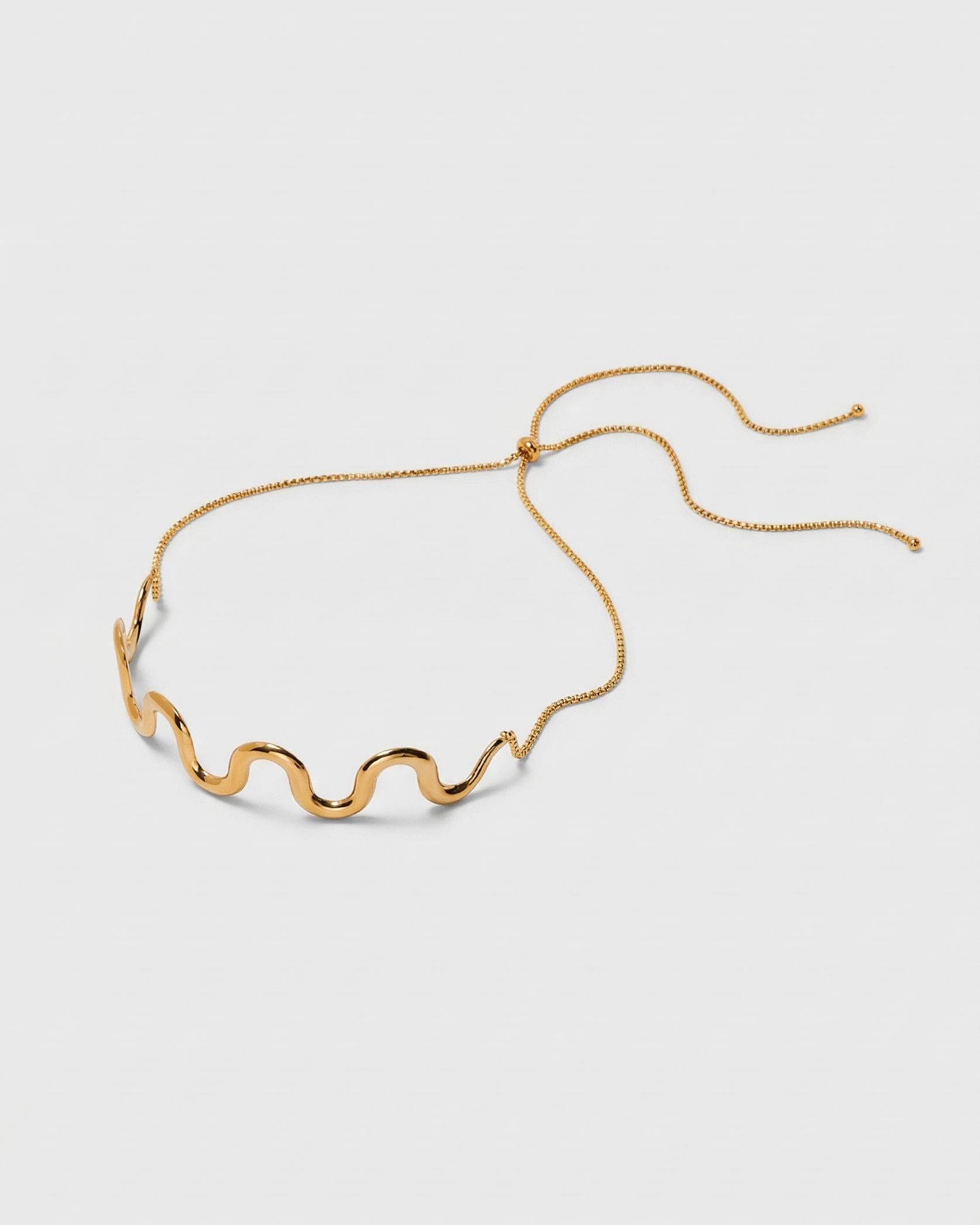 Gold necklace with a wavy design on a white background