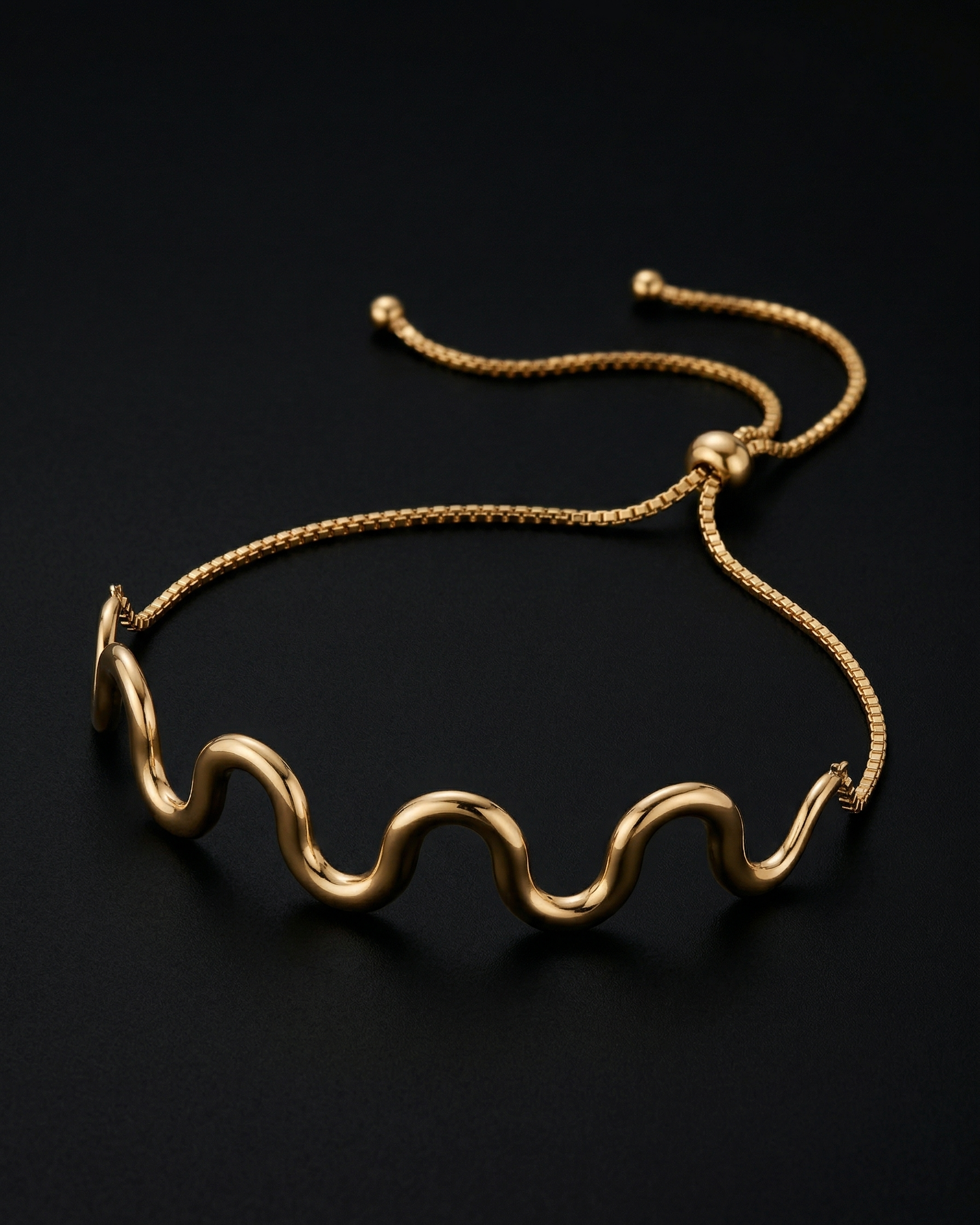 Gold bracelet with wavy design on a black background