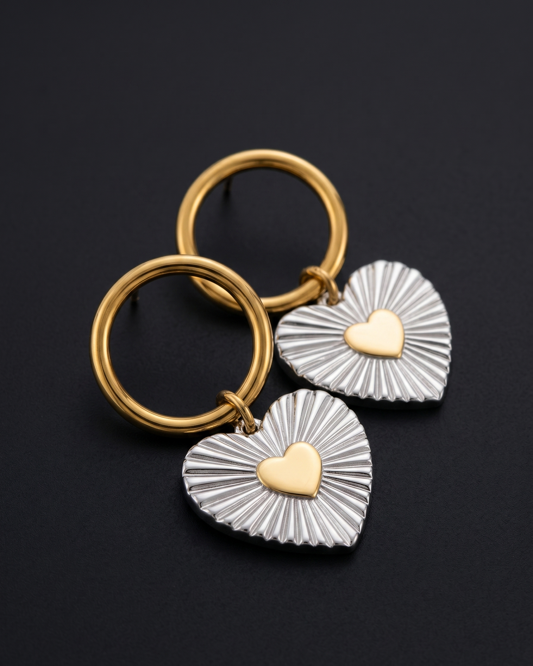 Two keychains with heart designs on a black background