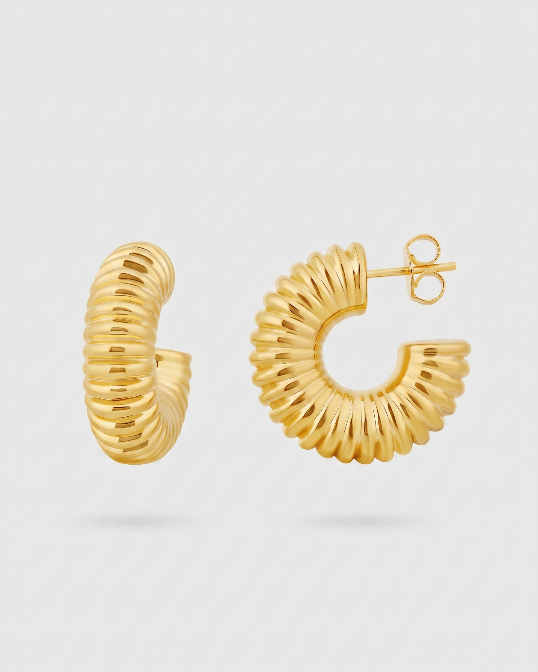 Gold hoop earrings on a light gray background