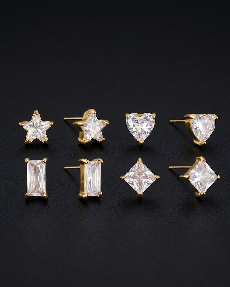 Set of diamond stud earrings with gold settings on a black background