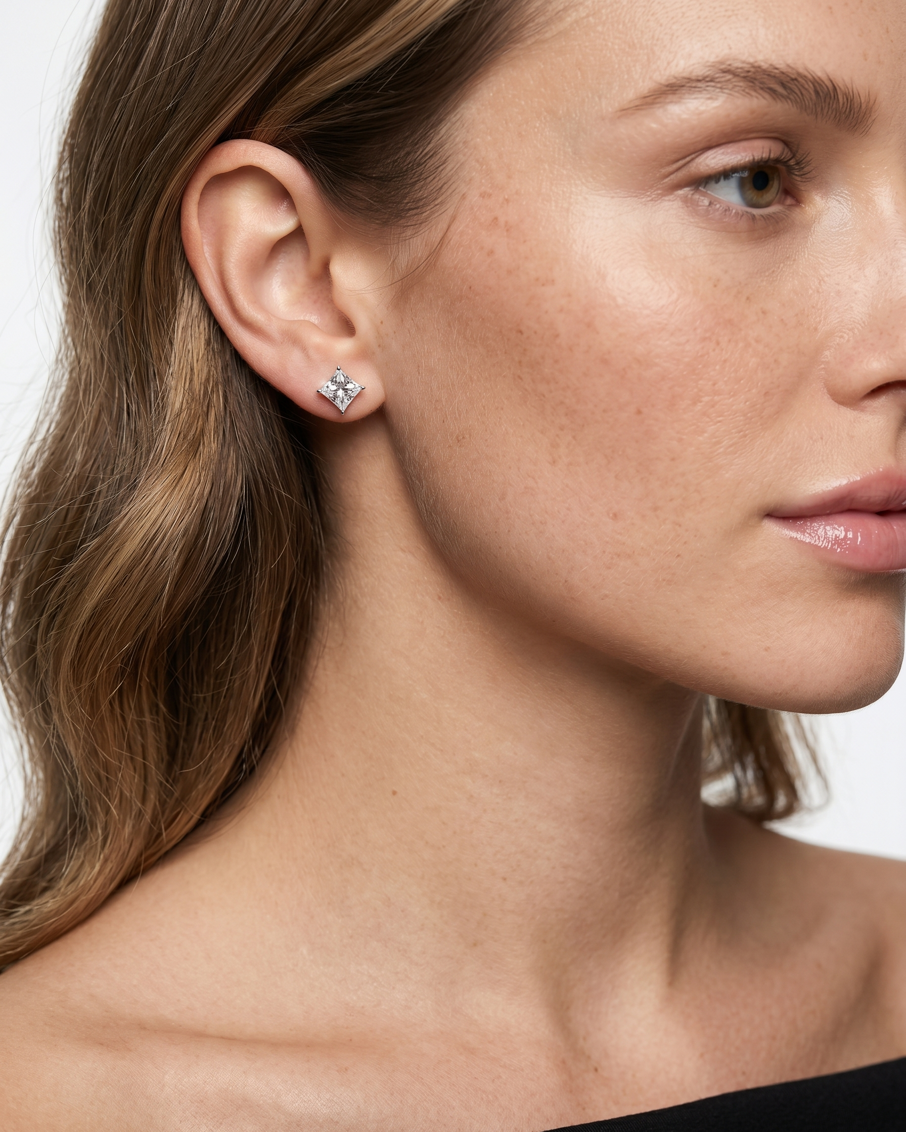 Close-up of a woman wearing a star-shaped earring with a plain background