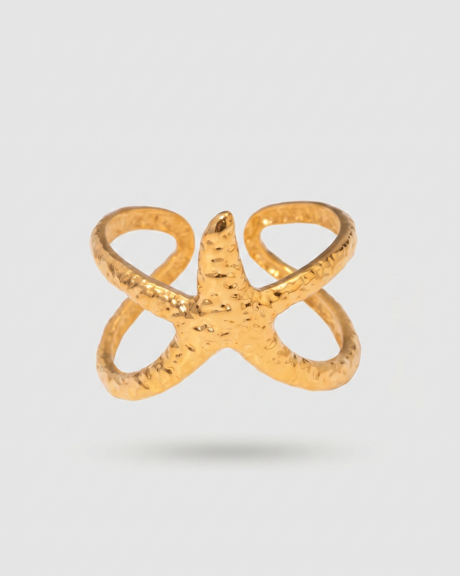 Gold ring with a unique design on a light gray background