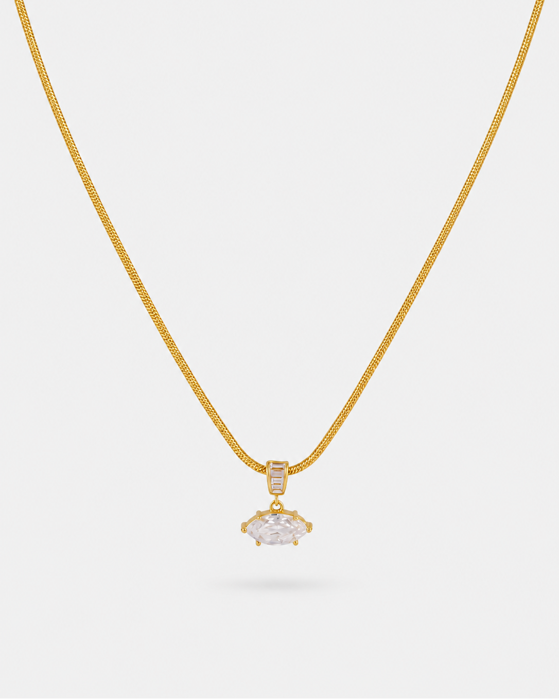 A delicate gold chain necklace with a small gold pendant featuring a clear marquise-cut gemstone and a tiny accent stone, displayed against a light gray background.