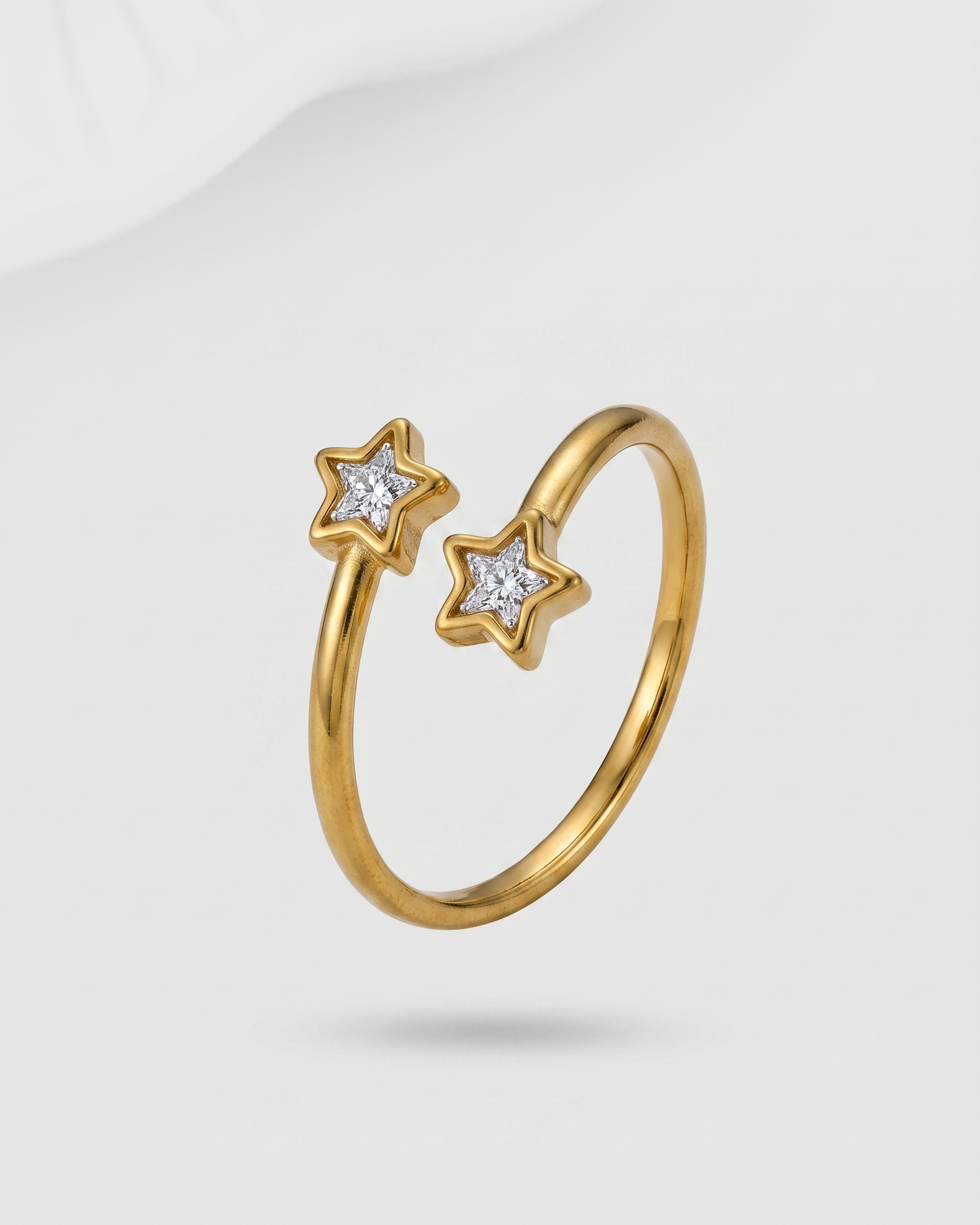 Gold ring with star-shaped gemstones on a light gray background