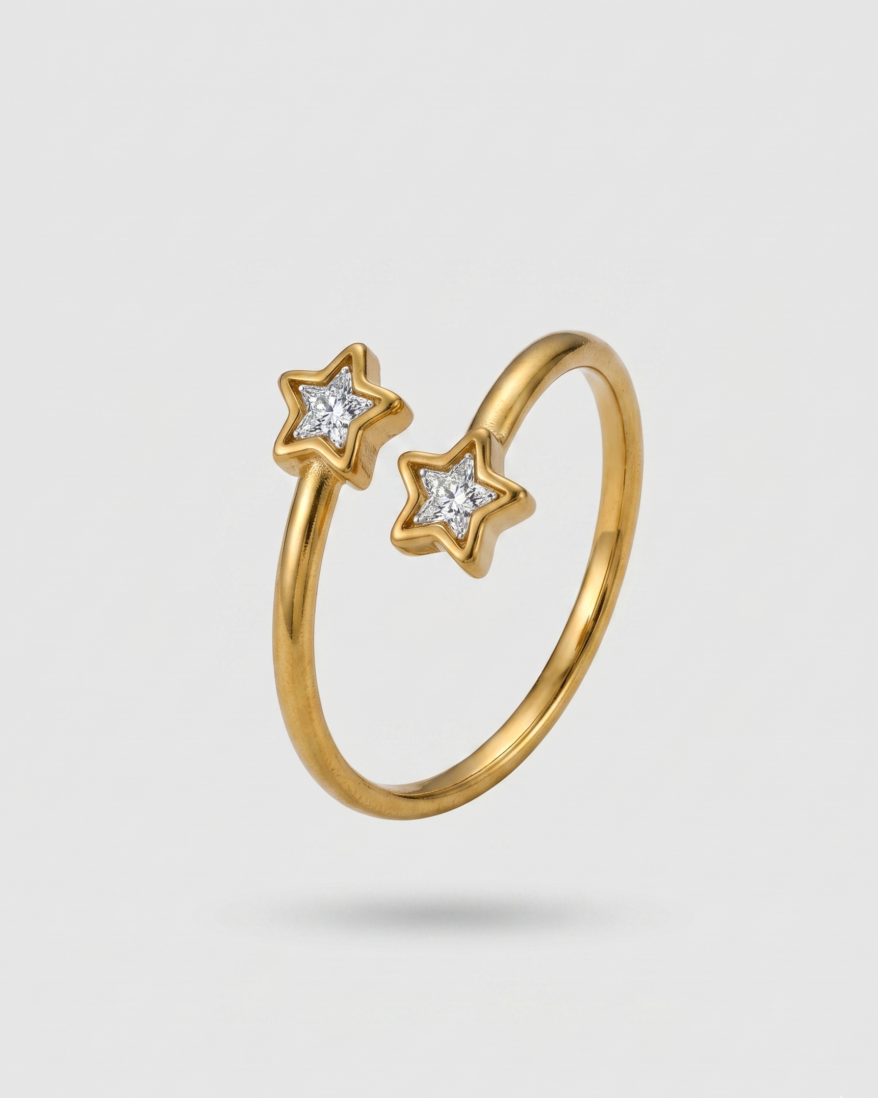 Gold ring with star-shaped diamond stones on a light gray background