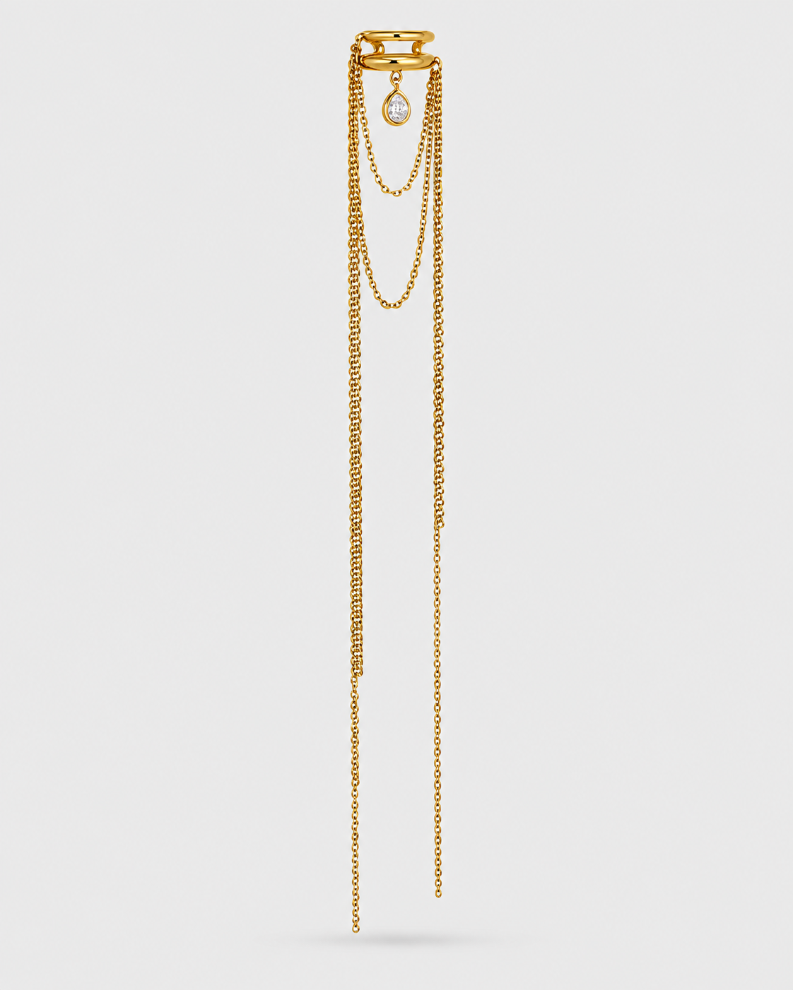 A gold-toned multi-strand chain necklace with a small oval pearl pendant, displayed against a solid light gray background.