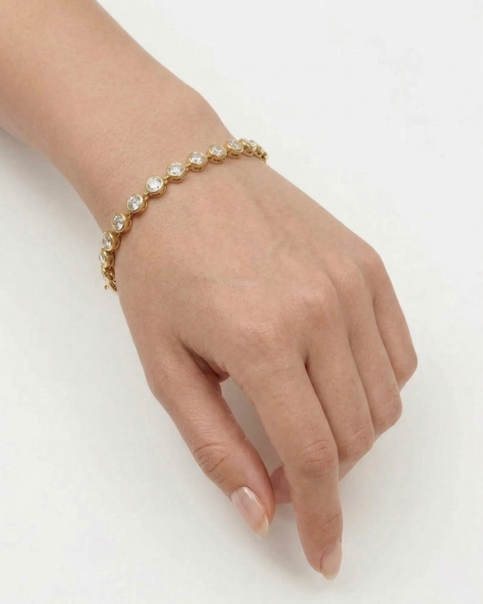 Hand wearing a pearl bracelet on a white background
