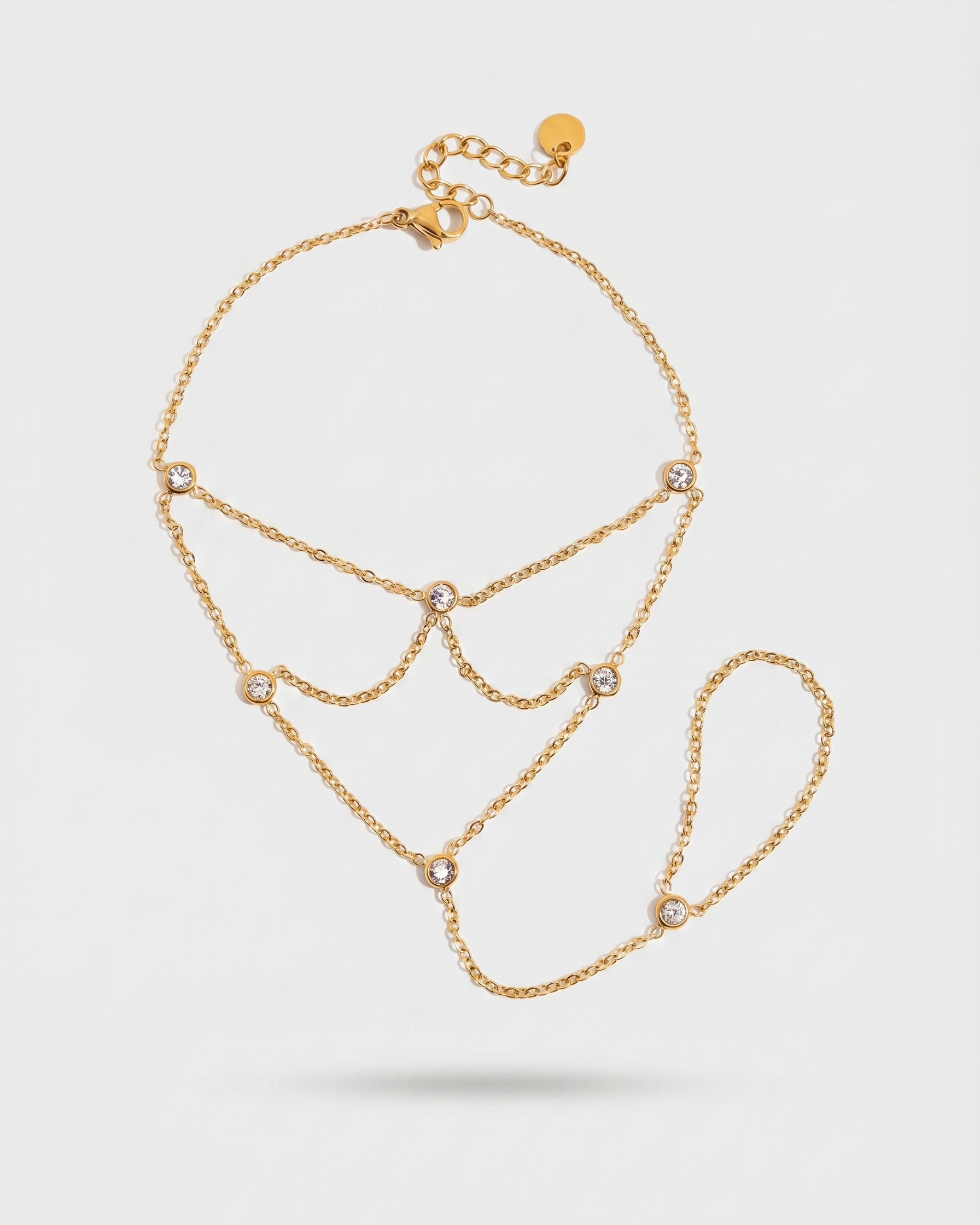 Gold chain necklace with small diamonds on a light gray background