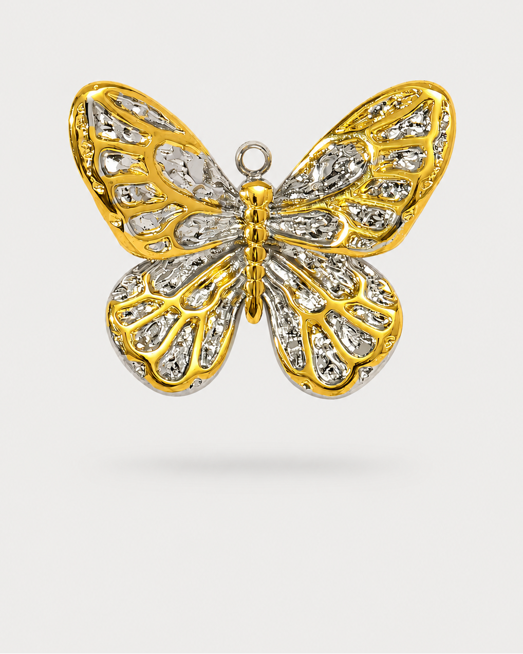 A butterfly-shaped pendant or brooch with gold-toned metal outlines and clear gemstones set across both wings, shown on a light gray background.
