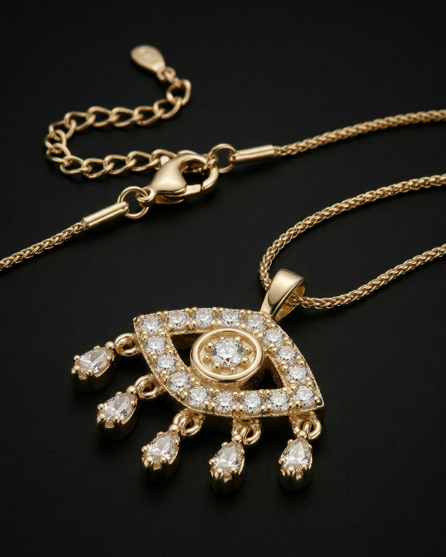 Gold necklace with an eye-shaped pendant on a black background
