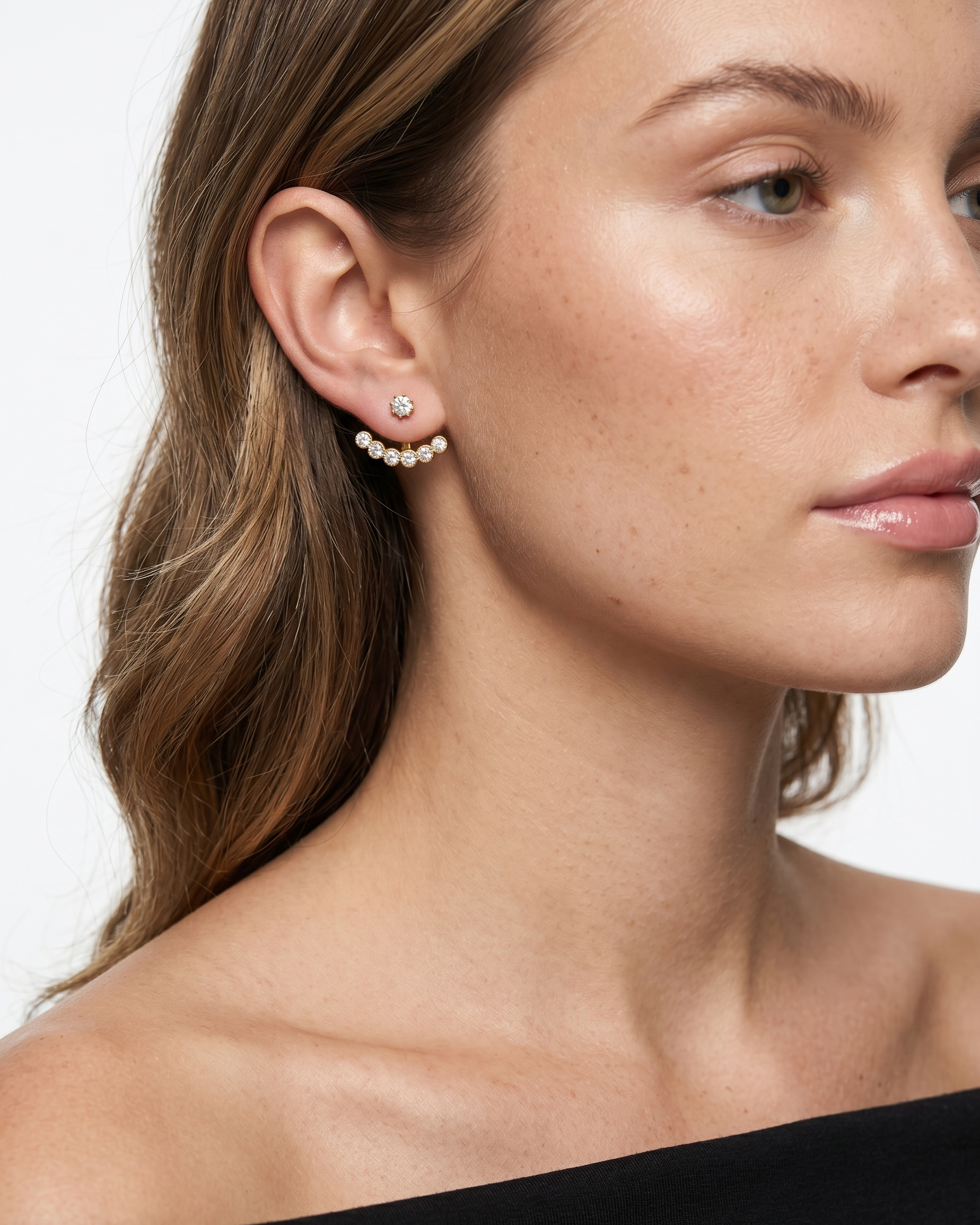 Close-up of a woman wearing pearl earrings with a neutral background