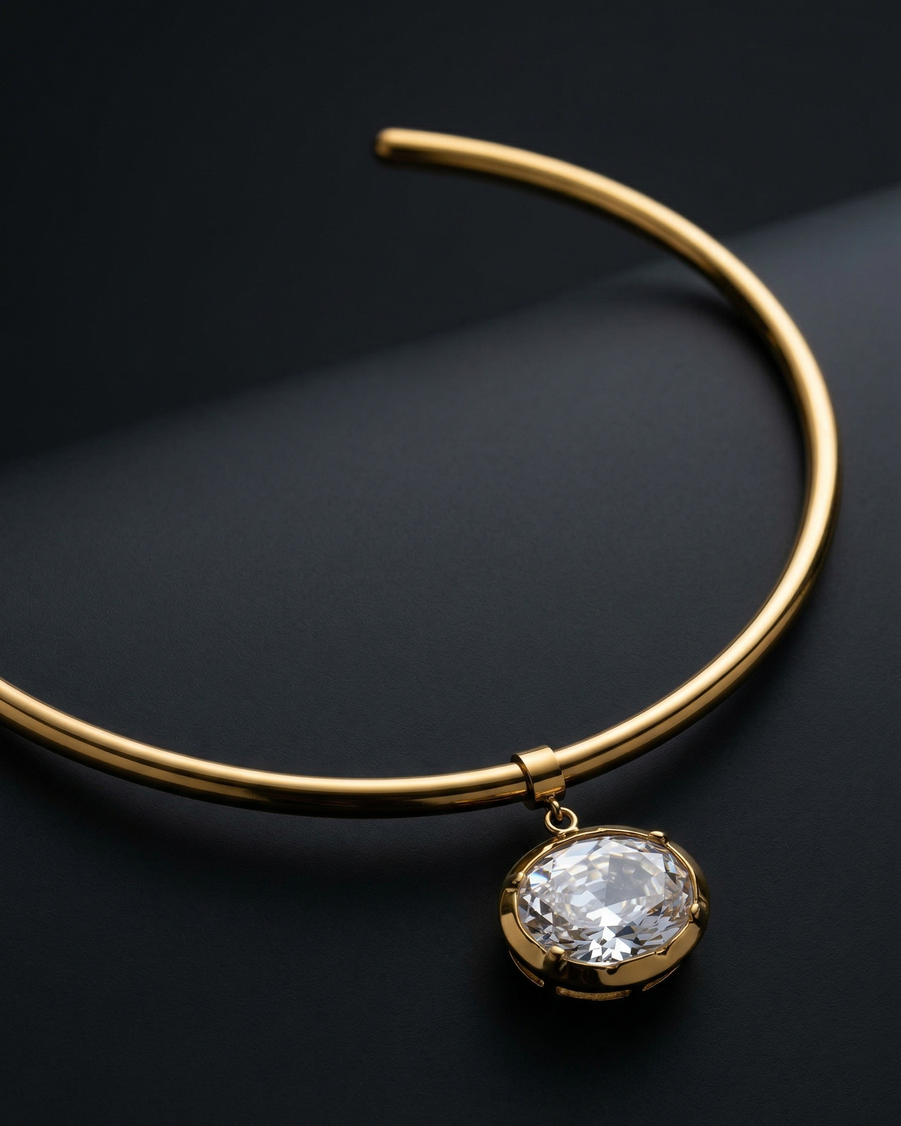 Gold necklace with a prominent diamond pendant on a dark background