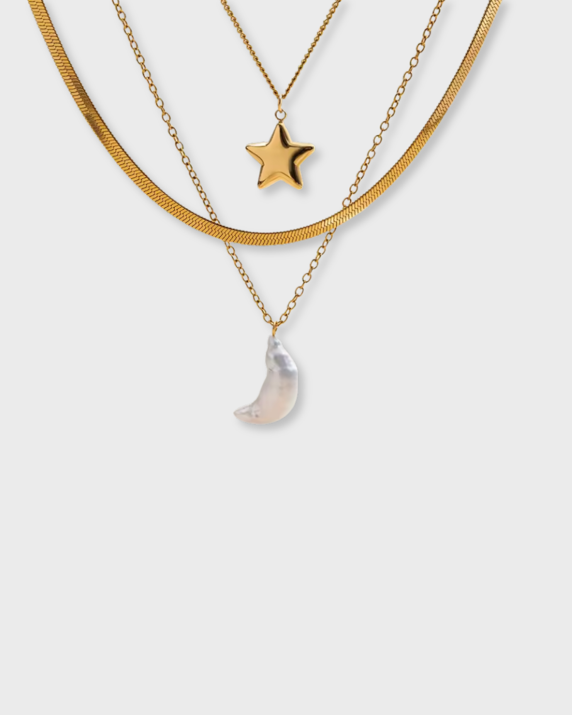Two gold necklaces with star and moon pendants on a white background