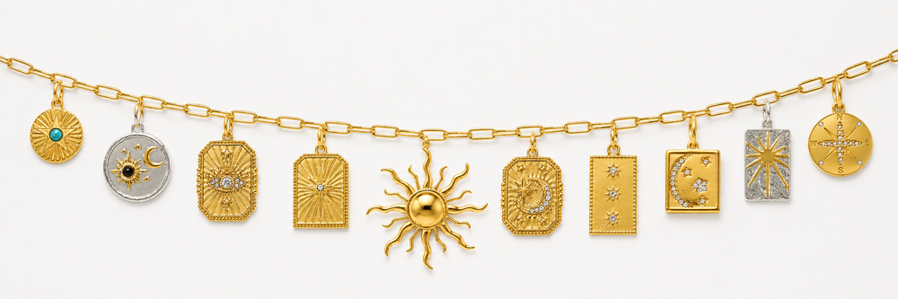 A gold chain bracelet featuring multiple celestial and geometric charms, including a prominent sun charm, crescent moon, stars, and sunburst designs, shown against a plain white background.